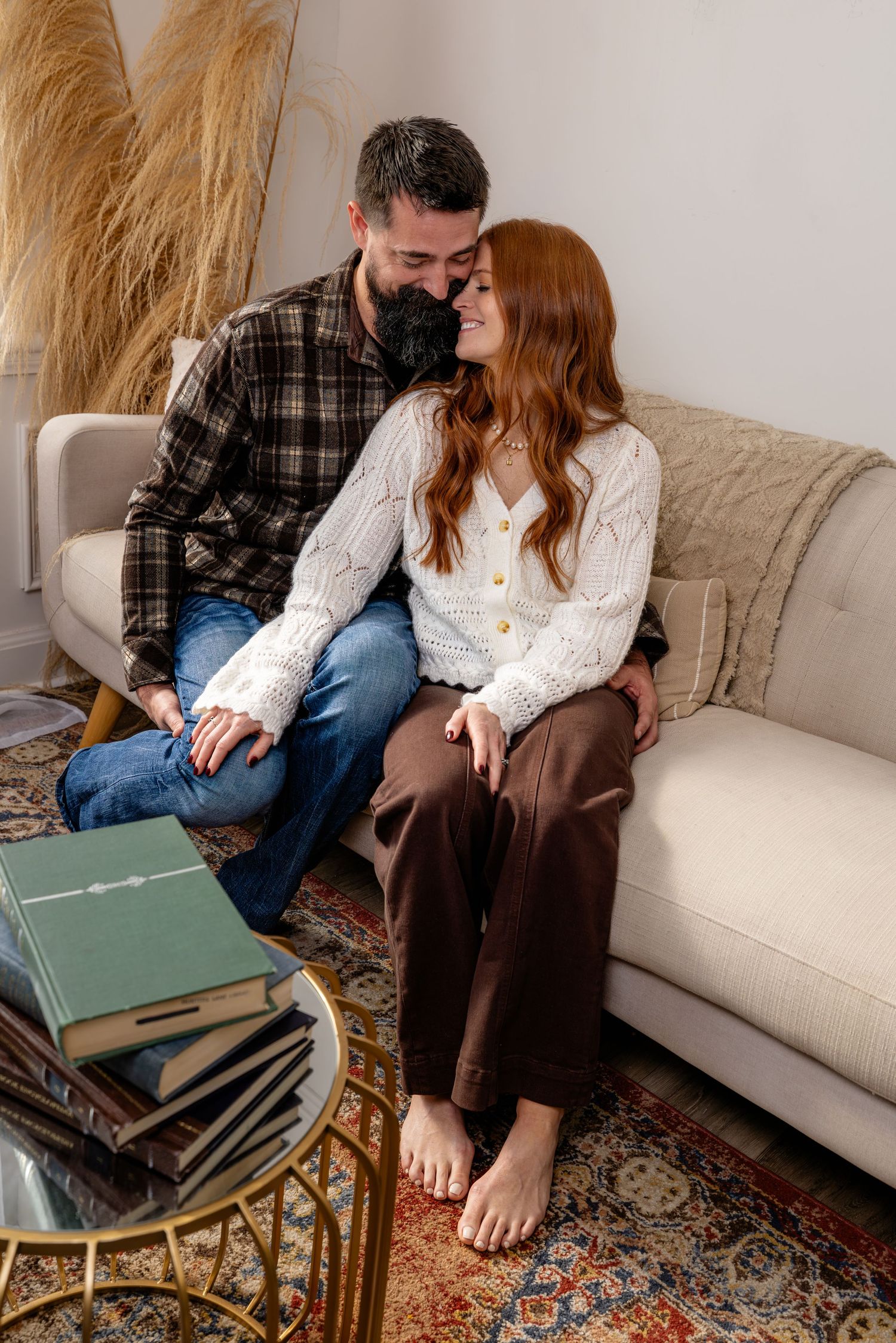A couple shares a tender moment on a cozy sofa, surrounded by books and warm decor at a session in Murfreesboro, Tennessee.