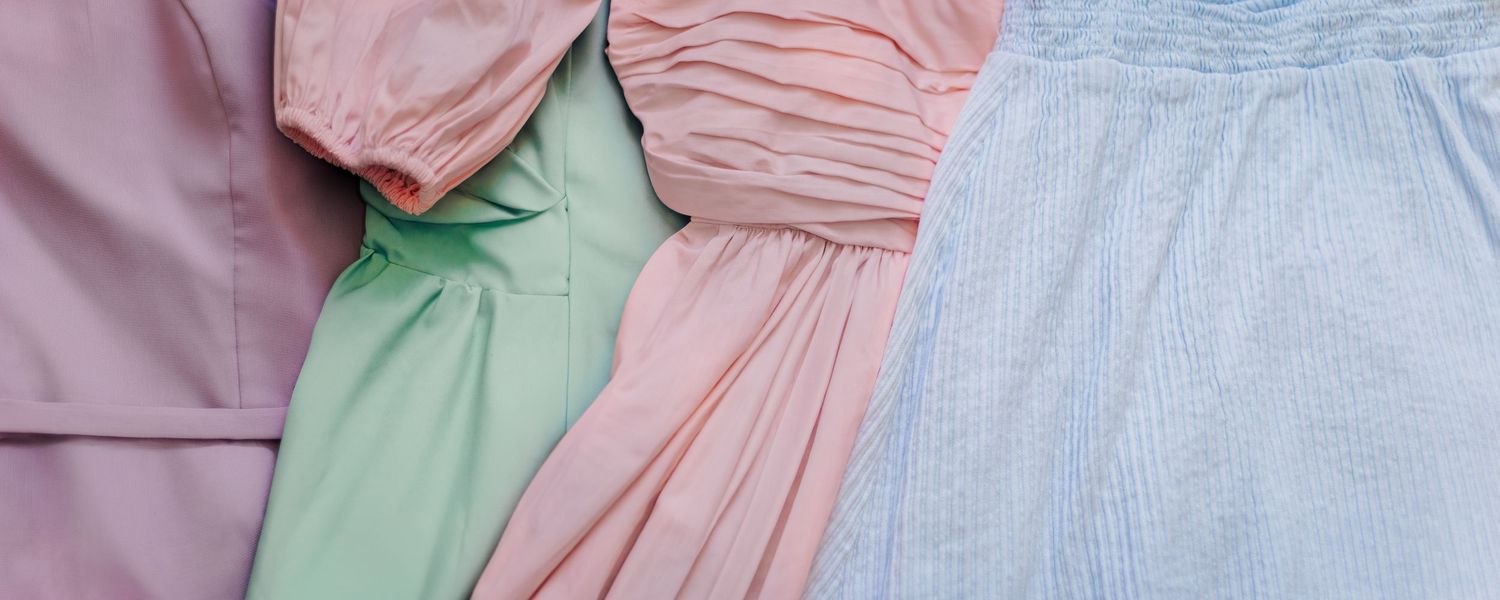 Soft pastel spring outfits in blush, sage green, lavender, and light blue styled for a family photography session