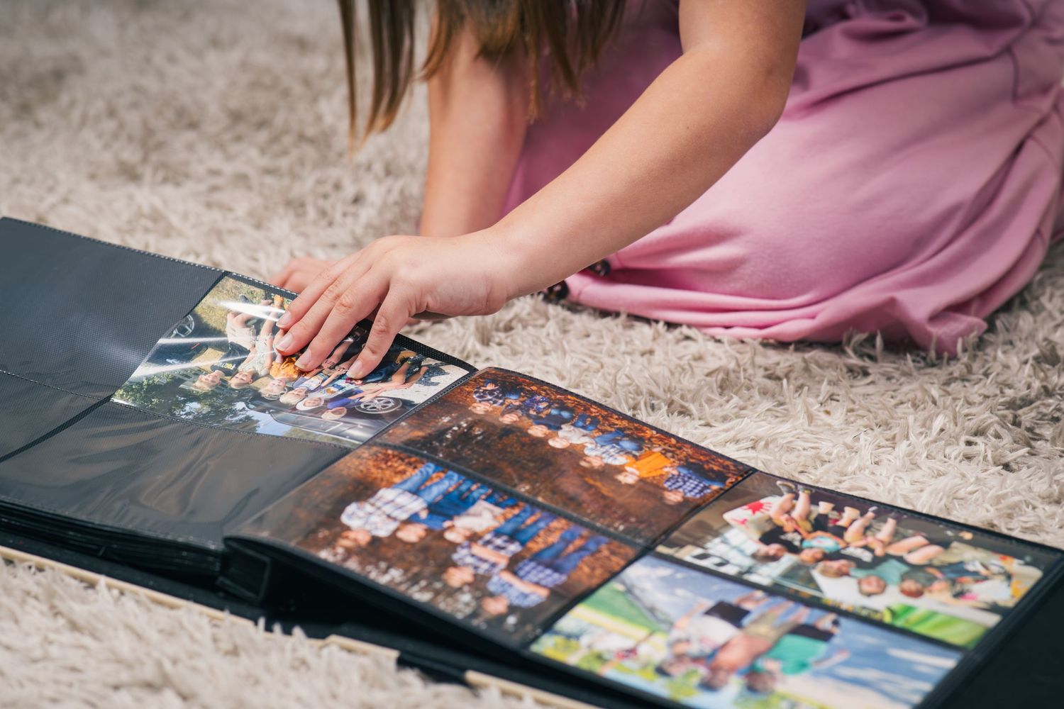 Child looking through a family photo album filled with printed memories from past photography sessions