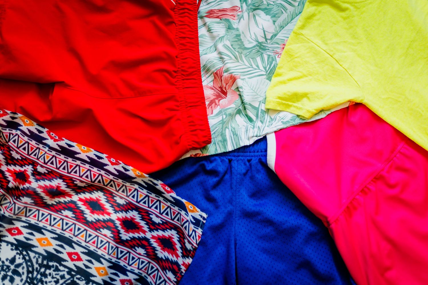 Bright and clashing outfit colors including red, neon pink, yellow, and bold patterns that can distract in family photos