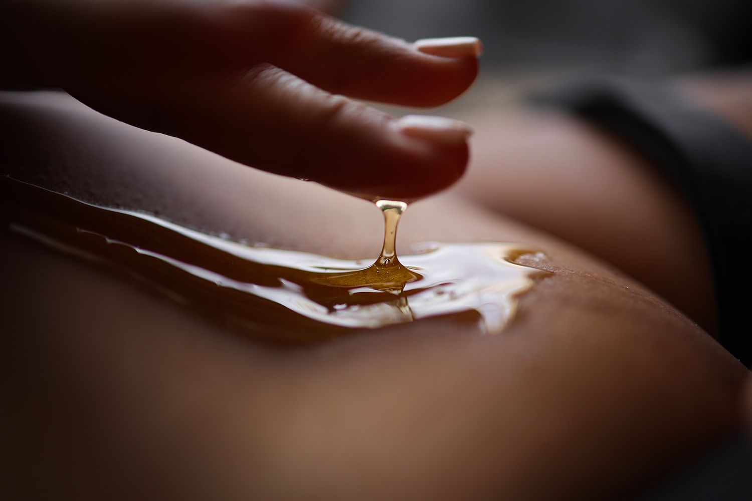 Artistic boudoir portrait of a woman wearing honey in a private studio