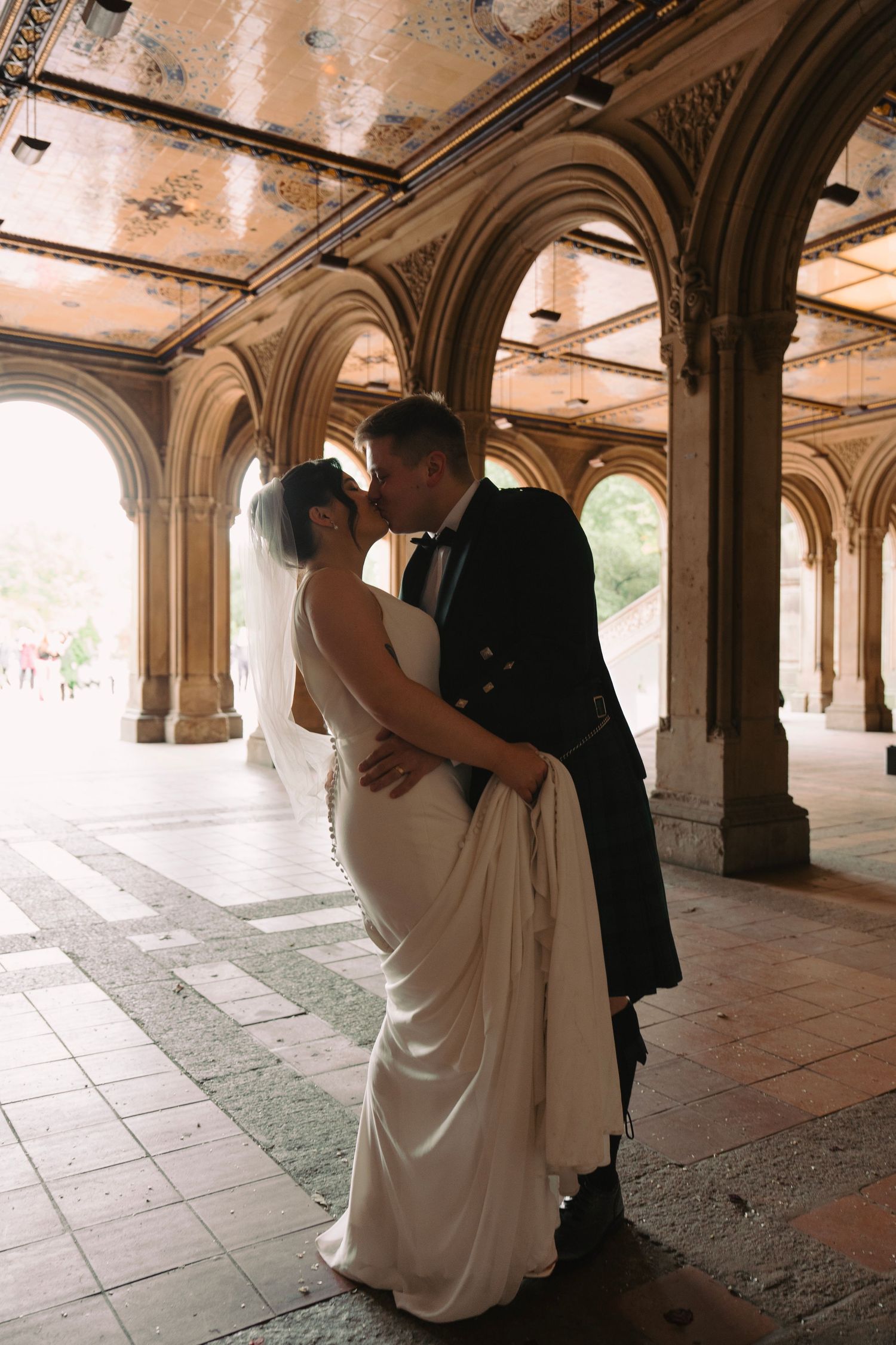Wedding couple dancing and embracing under historic stone archways in romantic sequence.