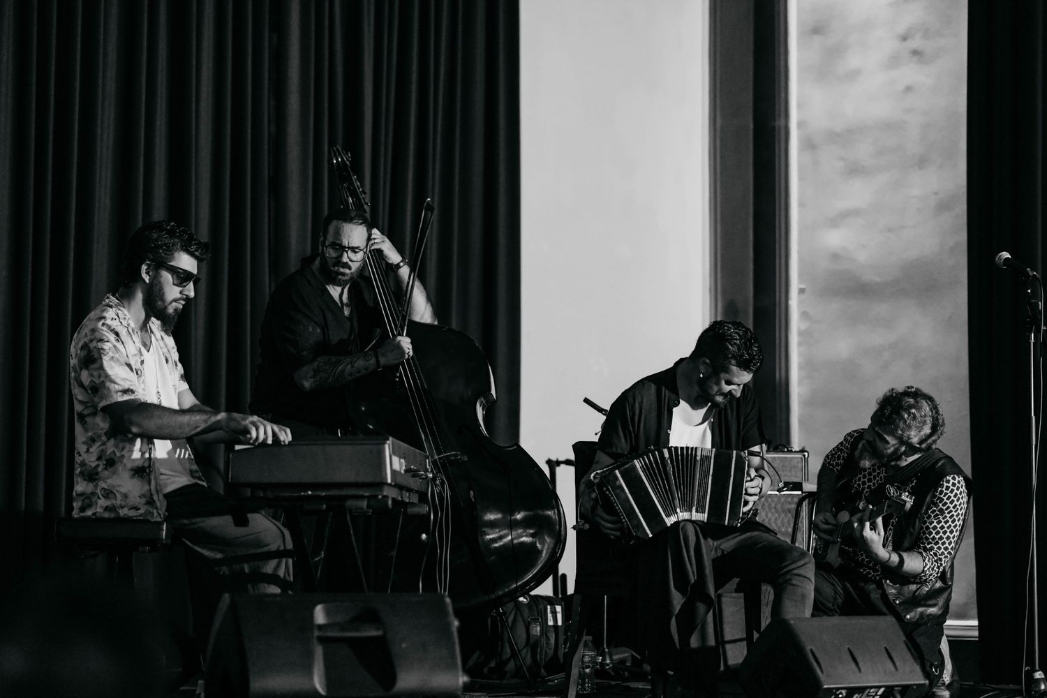 Musicians perform on stage in a black and white photograph series showing different angles of a live performance.