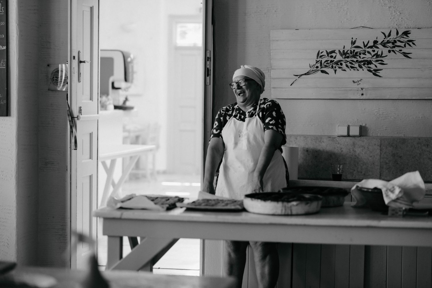 A black and white photo montage shows multiple interior scenes of a kitchen with people cooking and preparing food.