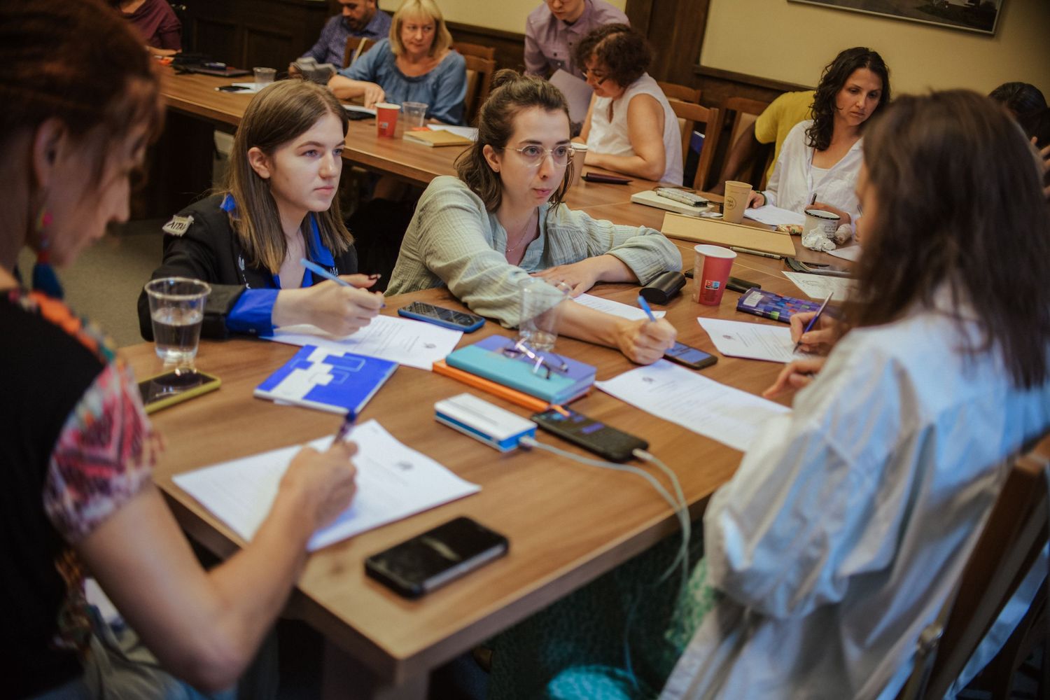 Students collaborating around a table during a workshop session.