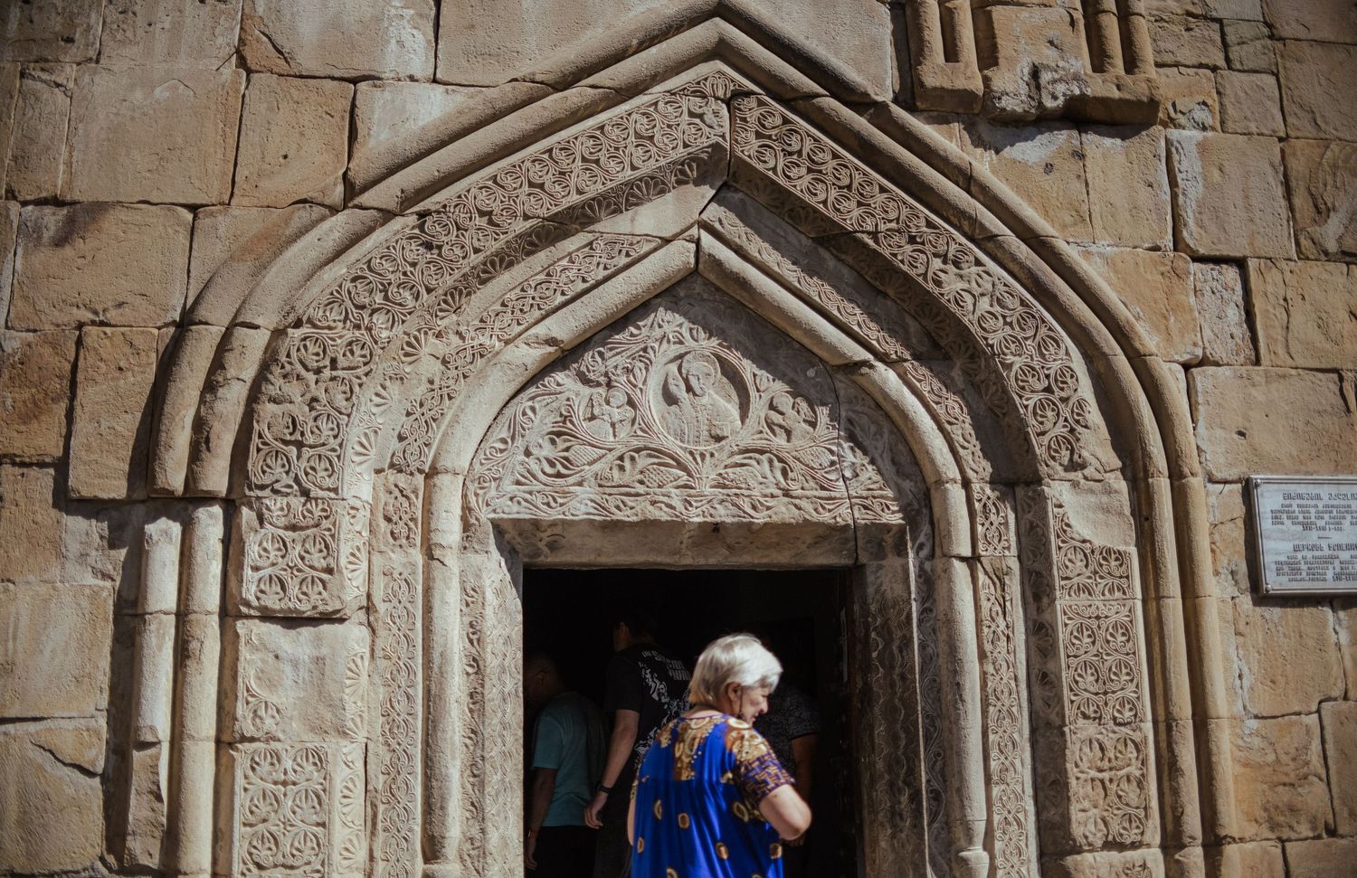 Ancient stone archway with intricate carvings and architectural details in a medieval church or monastery wall.