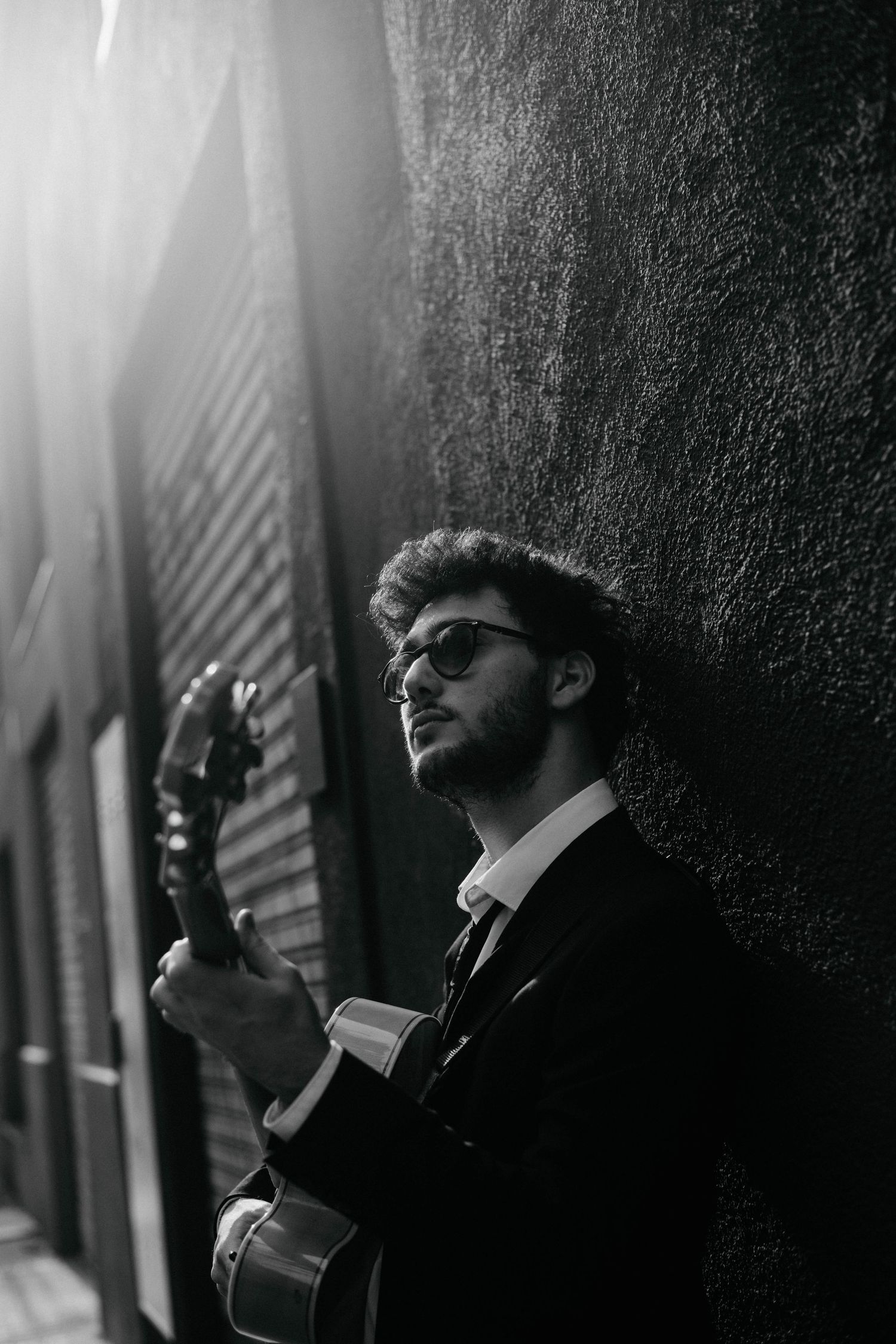 Black and white artistic photo sequence showing a person smoking against a dark wall with dramatic lighting.