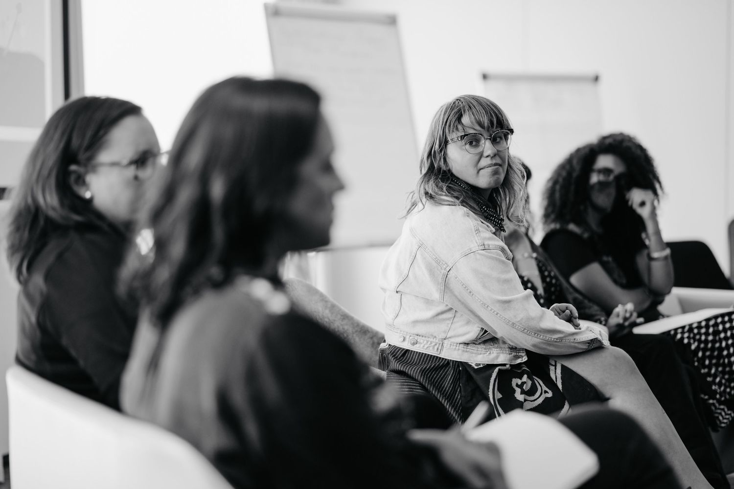 Black and white photo of attendees sitting and engaging during a professional workshop or meeting.