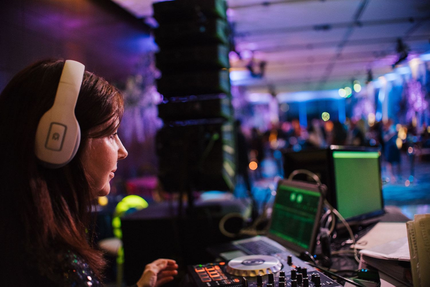 DJ booth setup with professional equipment and blue ambient lighting.