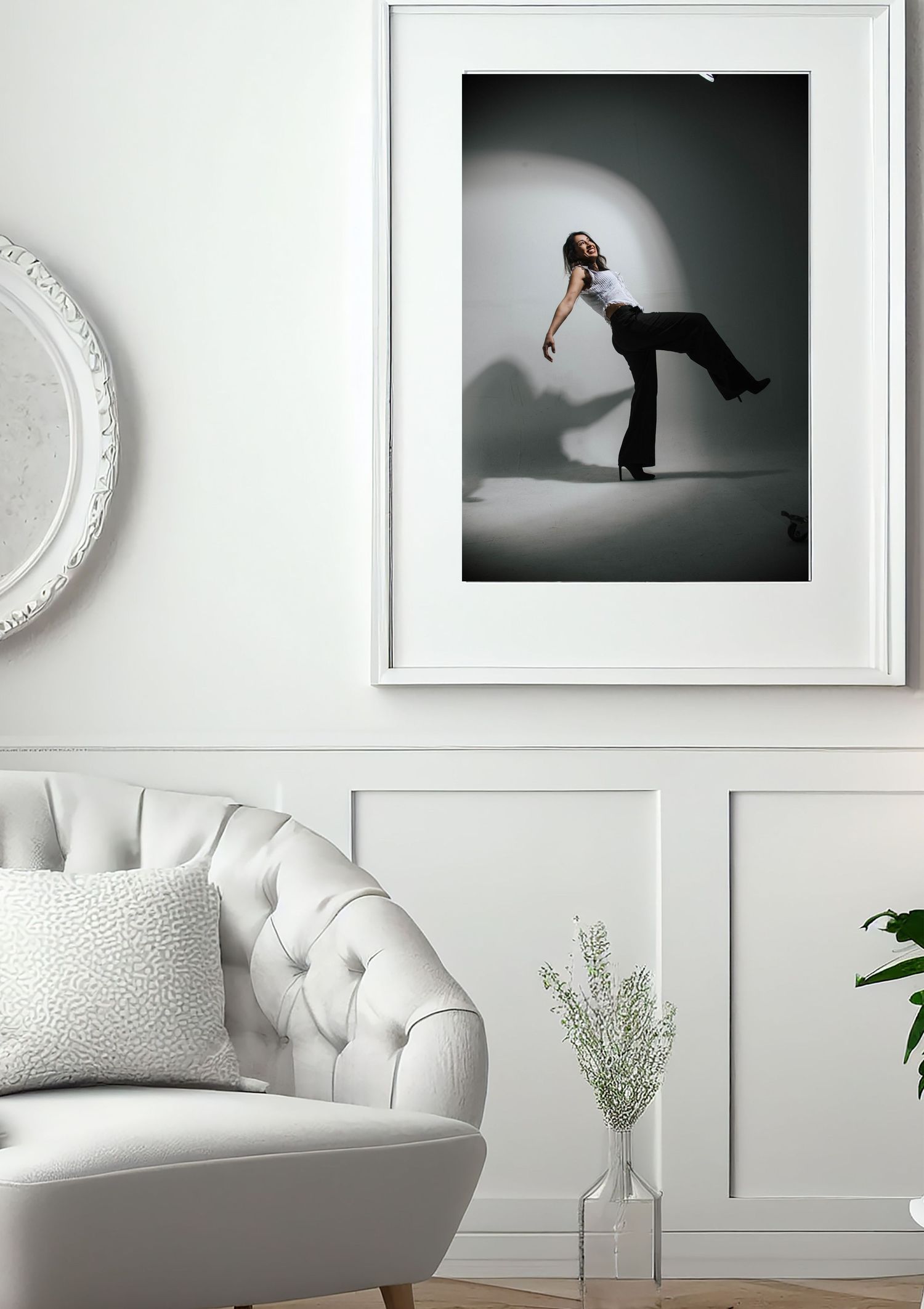 A collection of minimalist black and white dance photographs displayed on a white wall with tufted furniture below.