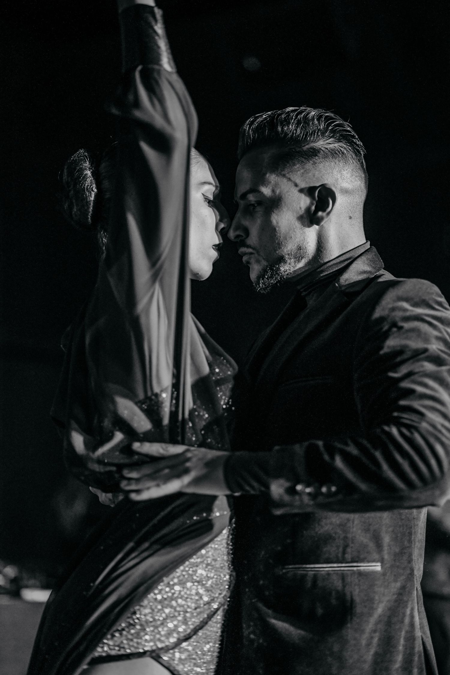 Intimate black and white photo of dancers in close embrace during a partner dance.