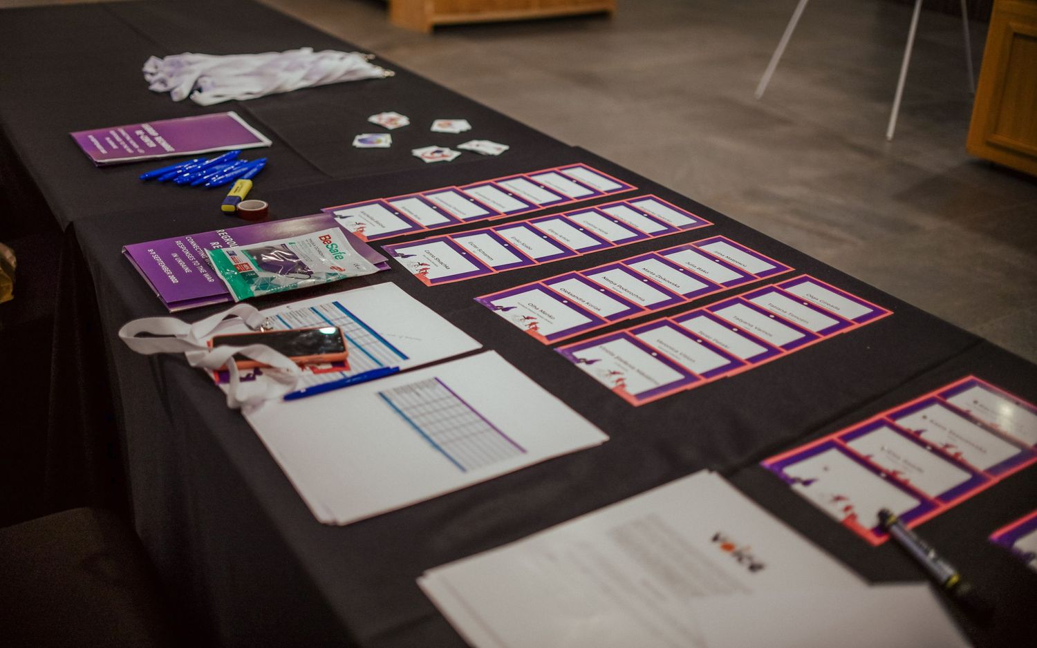 Conference materials and documents laid out on a dark table surface.