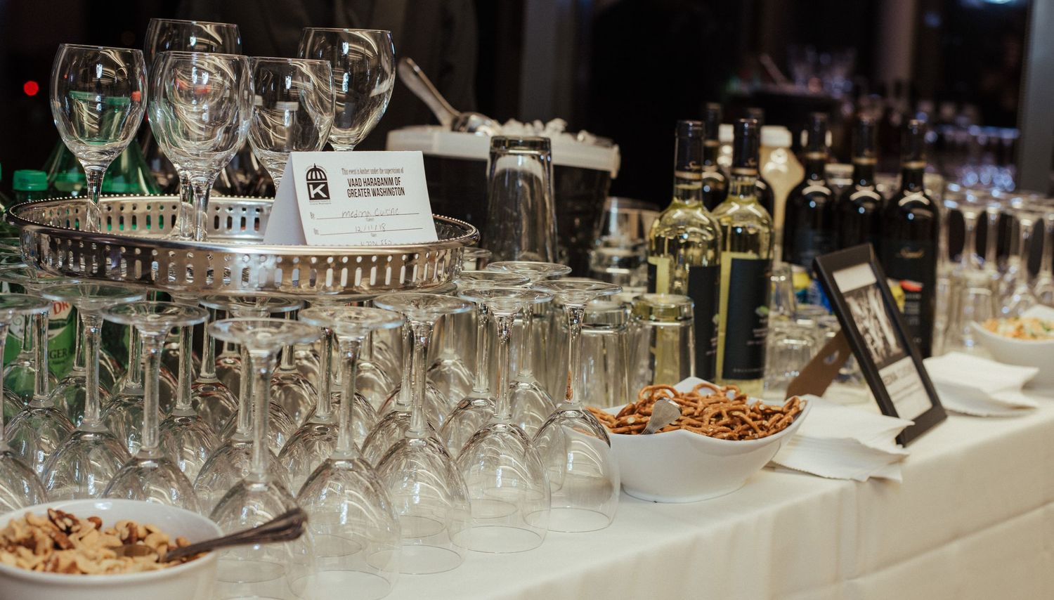 Elegant banquet table setup with rows of empty wine glasses and appetizer plates.