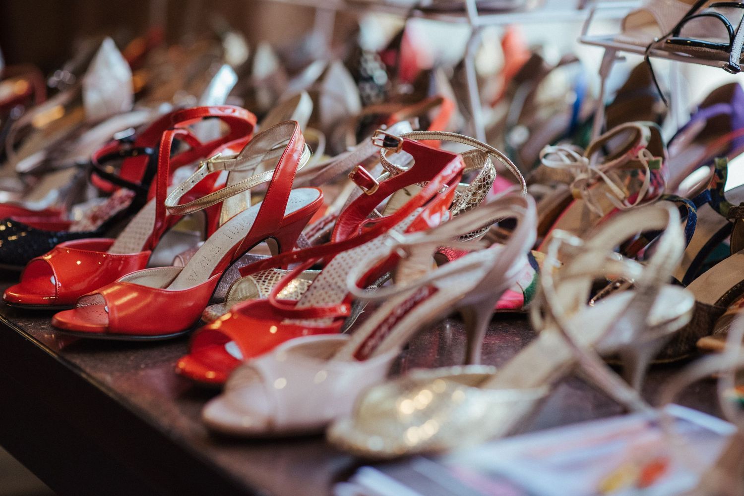 Row of red and white dance shoes lined up on display.