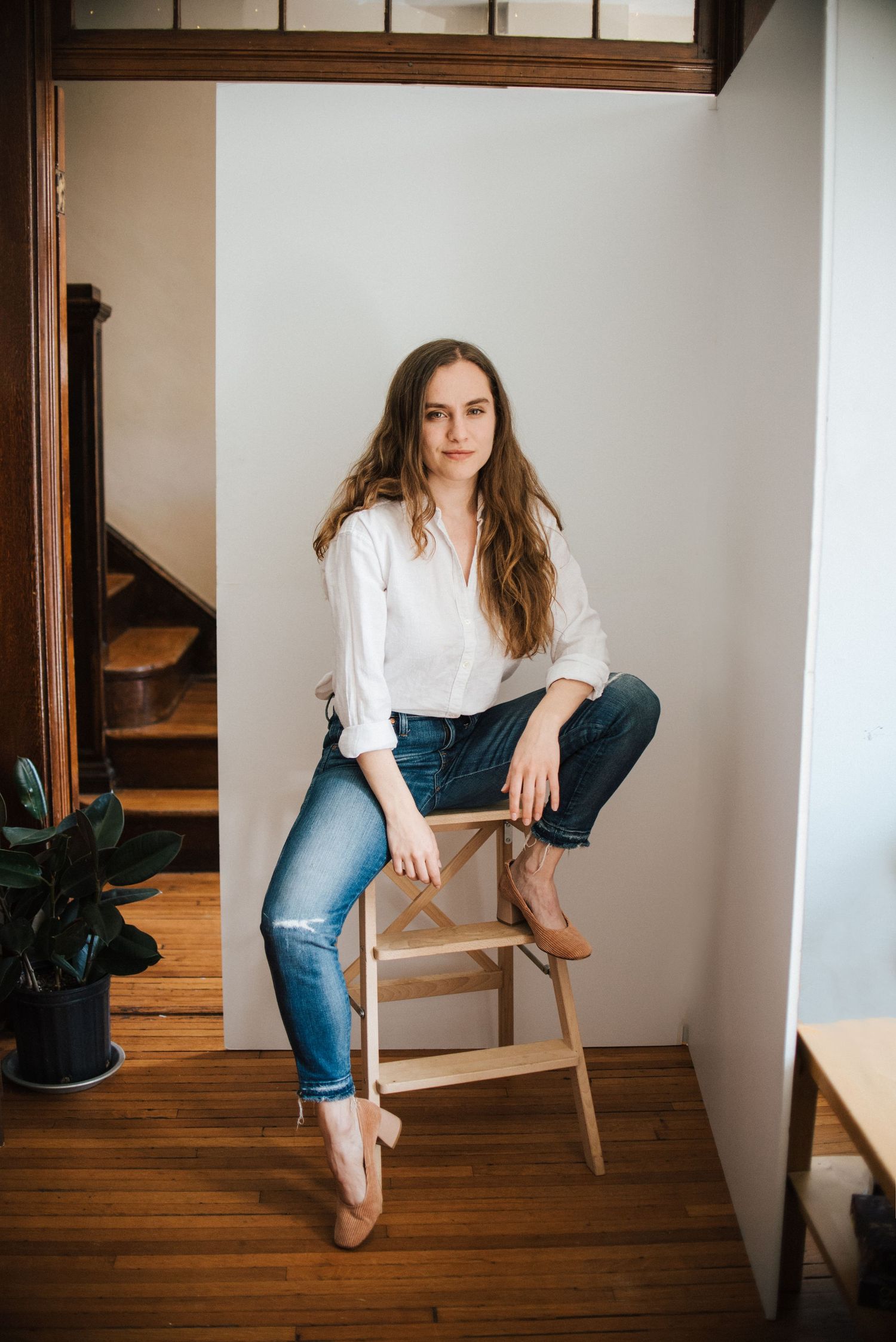 A series of minimalist portraits showing someone in white shirt and jeans sitting on wooden stairs in different poses.