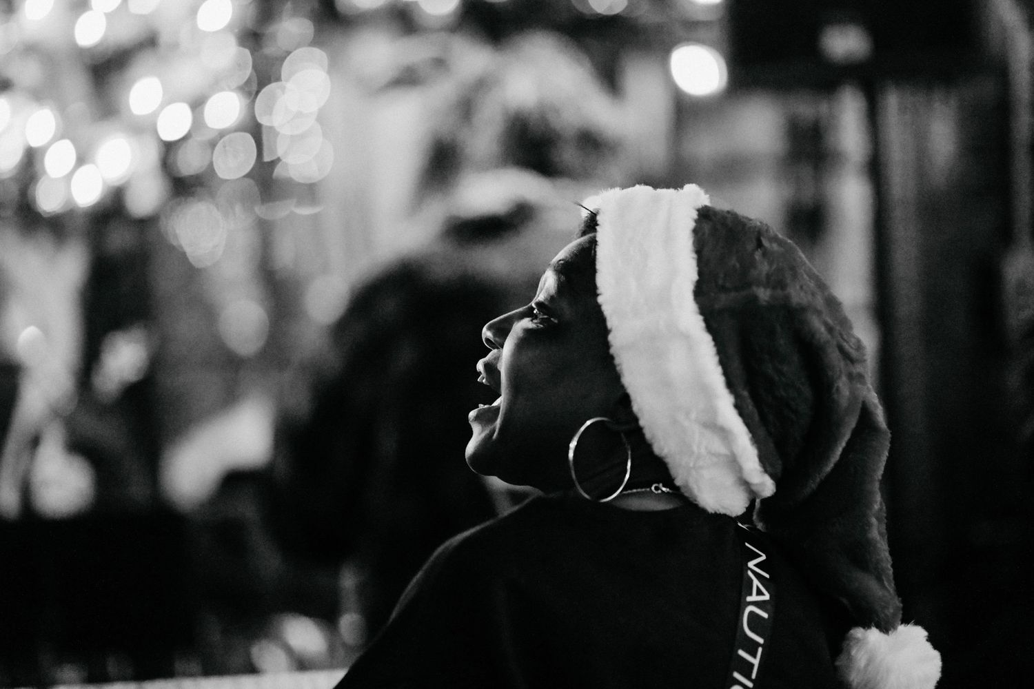 A black and white photo showing silhouettes of people dancing at a party with blurred lights in the background.