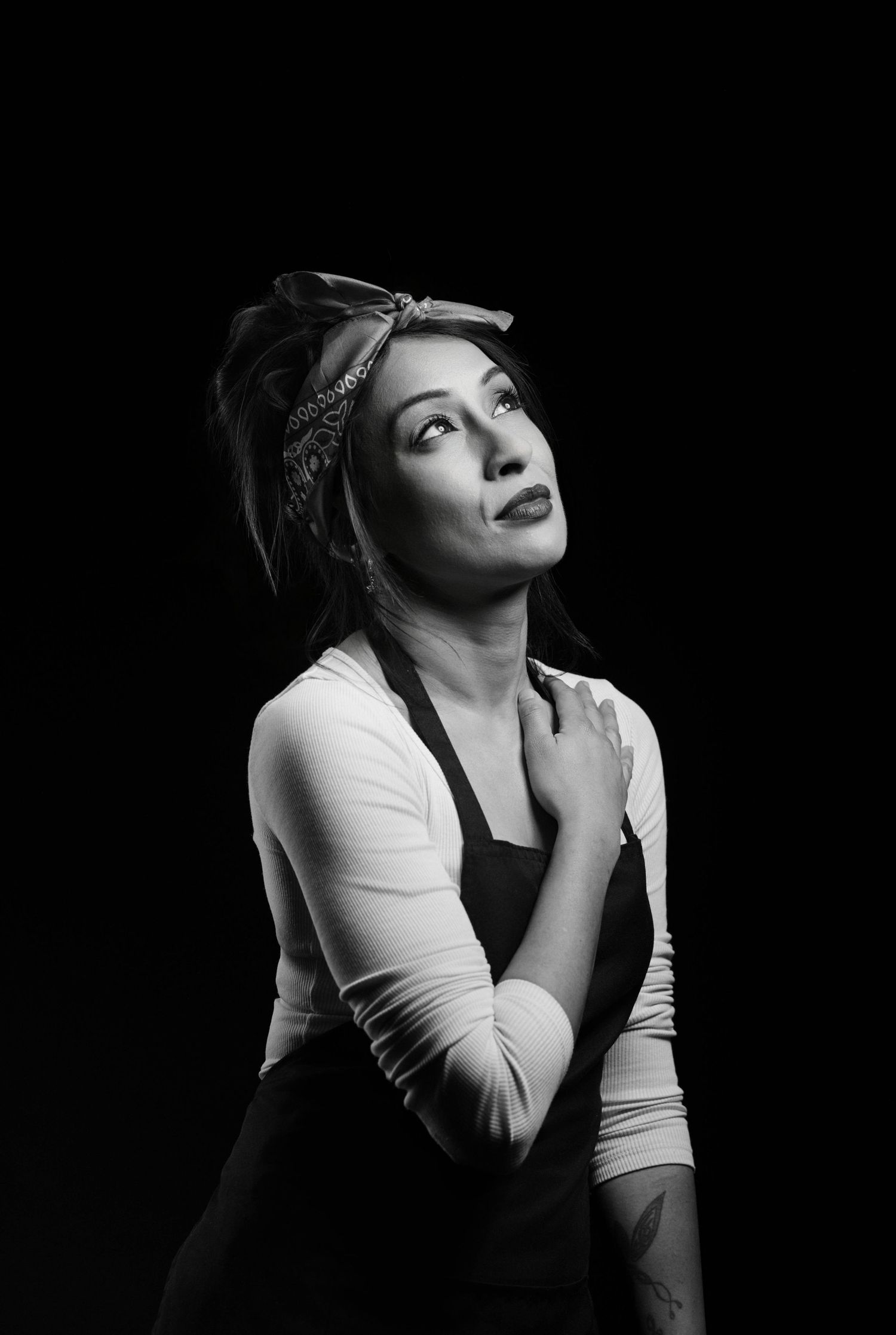 A dramatic black and white portrait series showing different poses and expressions in moody lighting.