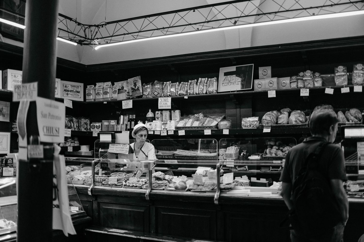 Long counter display cases in a retail store show various products under bright lighting.