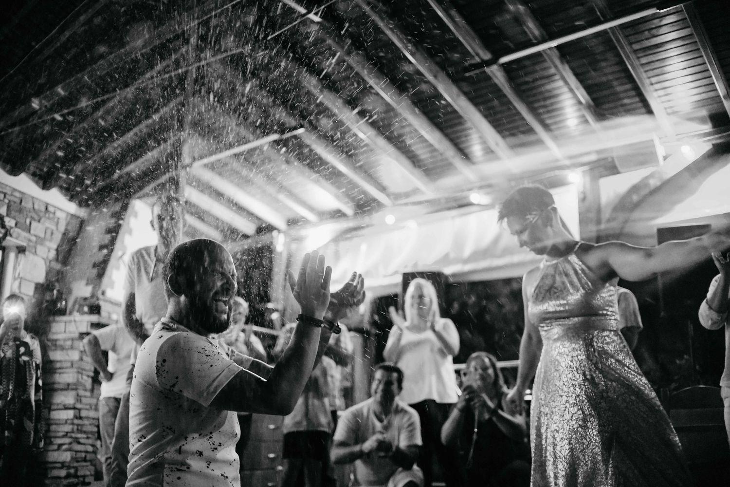 A lively dance party with people dancing and celebrating on a crowded dance floor under indoor lighting.