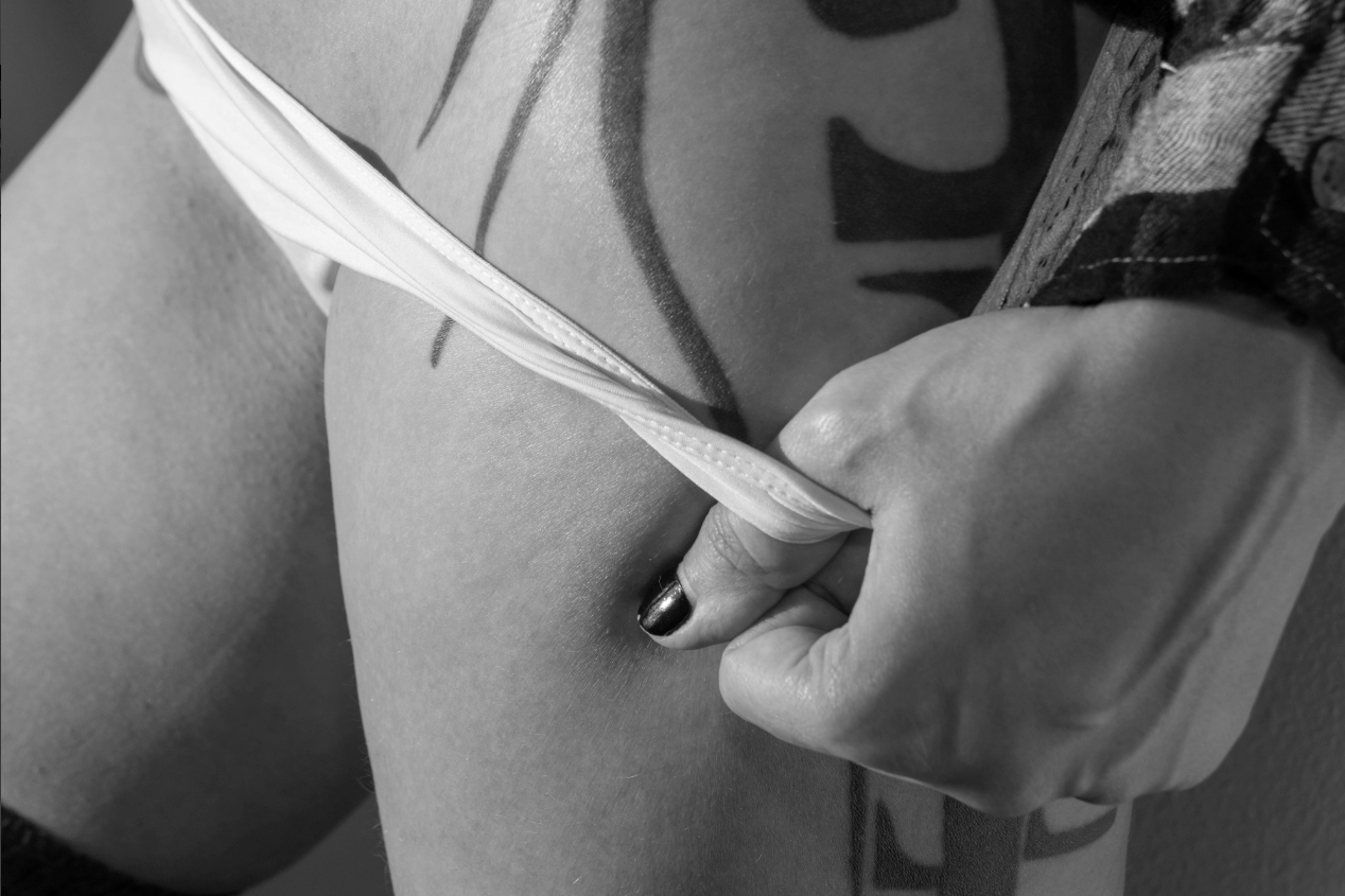 Boudoir black and white photo sliding white panties down from hip