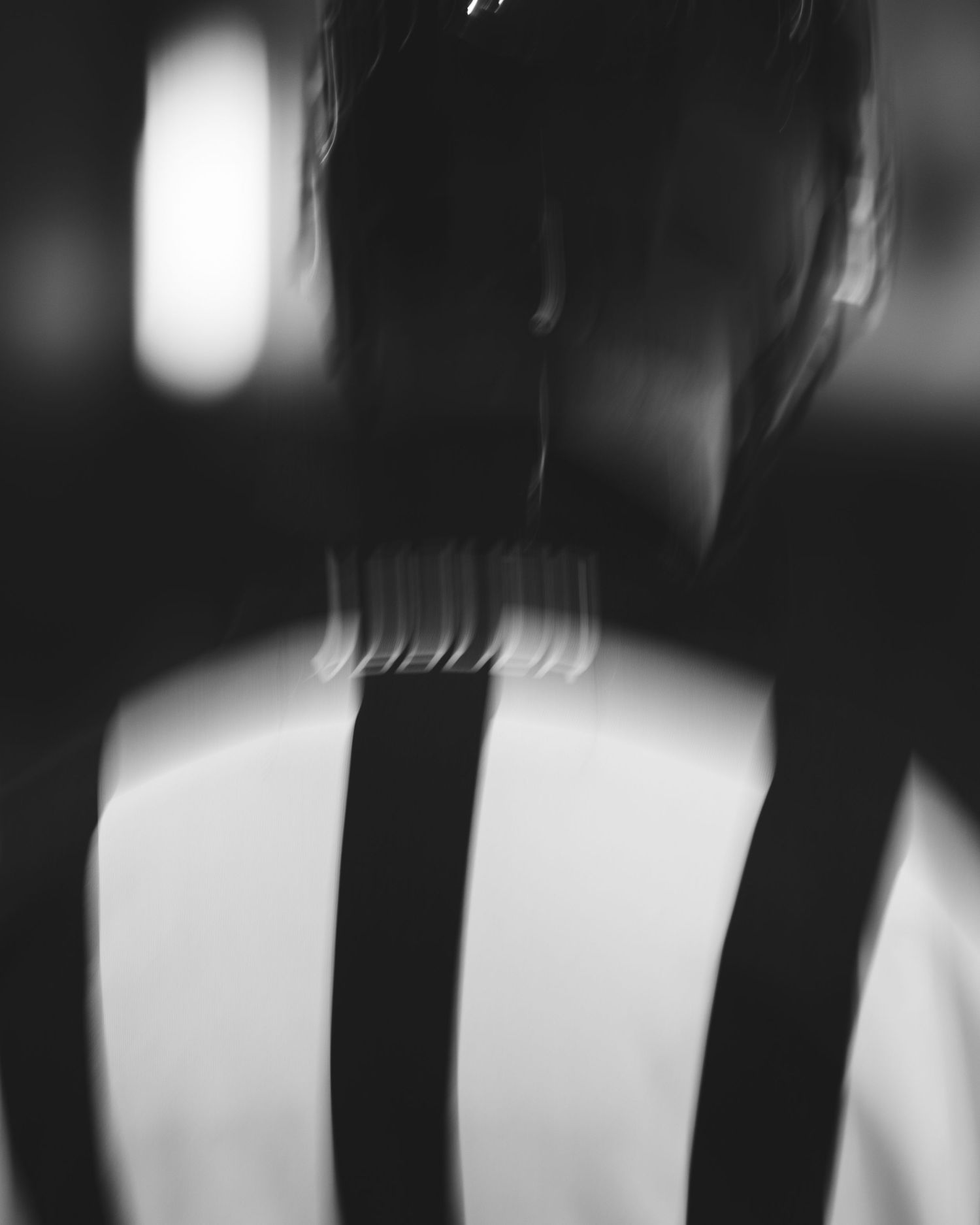 Abstract black and white pattern of vertical bars creating a moody minimalist composition with blurred edges.