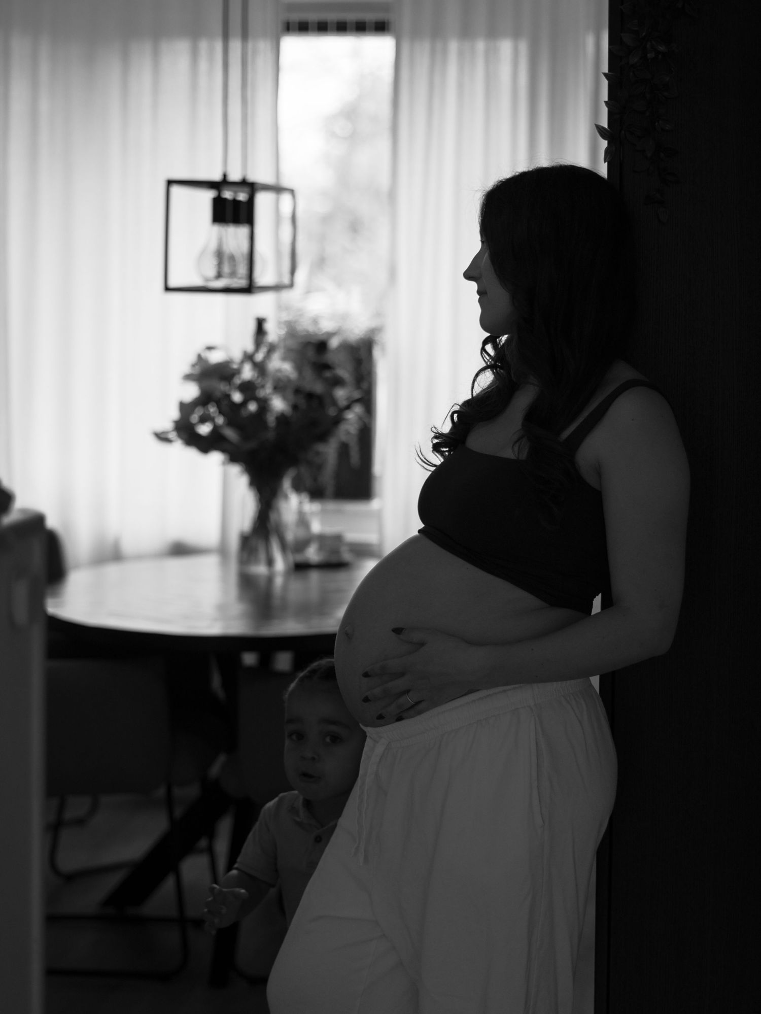 A series of black and white photos showing an intimate dance between two people in silhouette against white curtains.