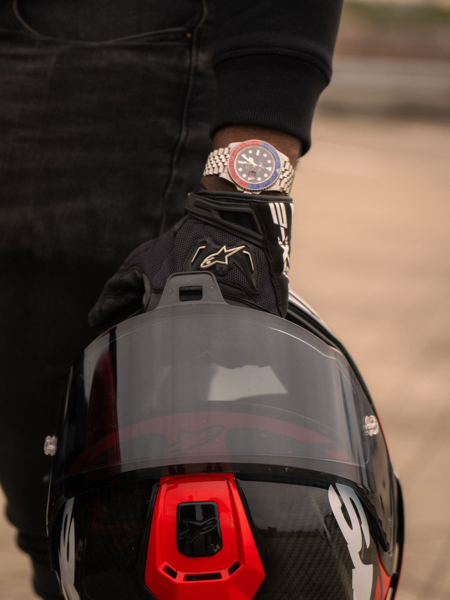 A close-up sequence of a black motorcycle helmet with red accents and reflective visor shown from different angles.