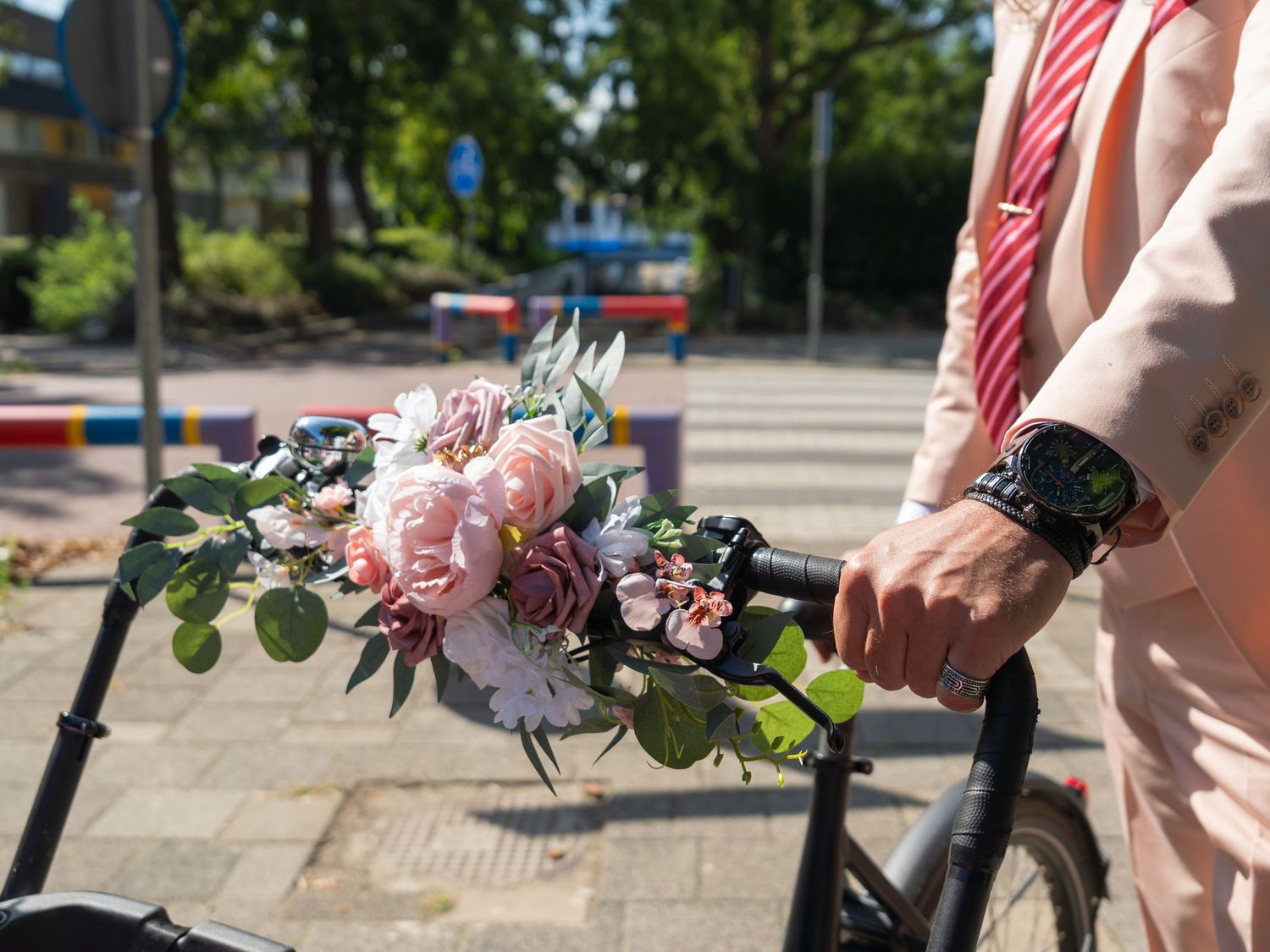 A series of hands holding pink and white floral bouquets outdoors against a sunny backdrop.