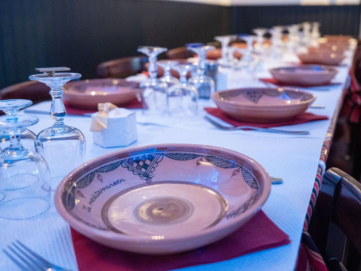Elegant table setting with brown plates and wine glasses arranged in a formal dining setup.