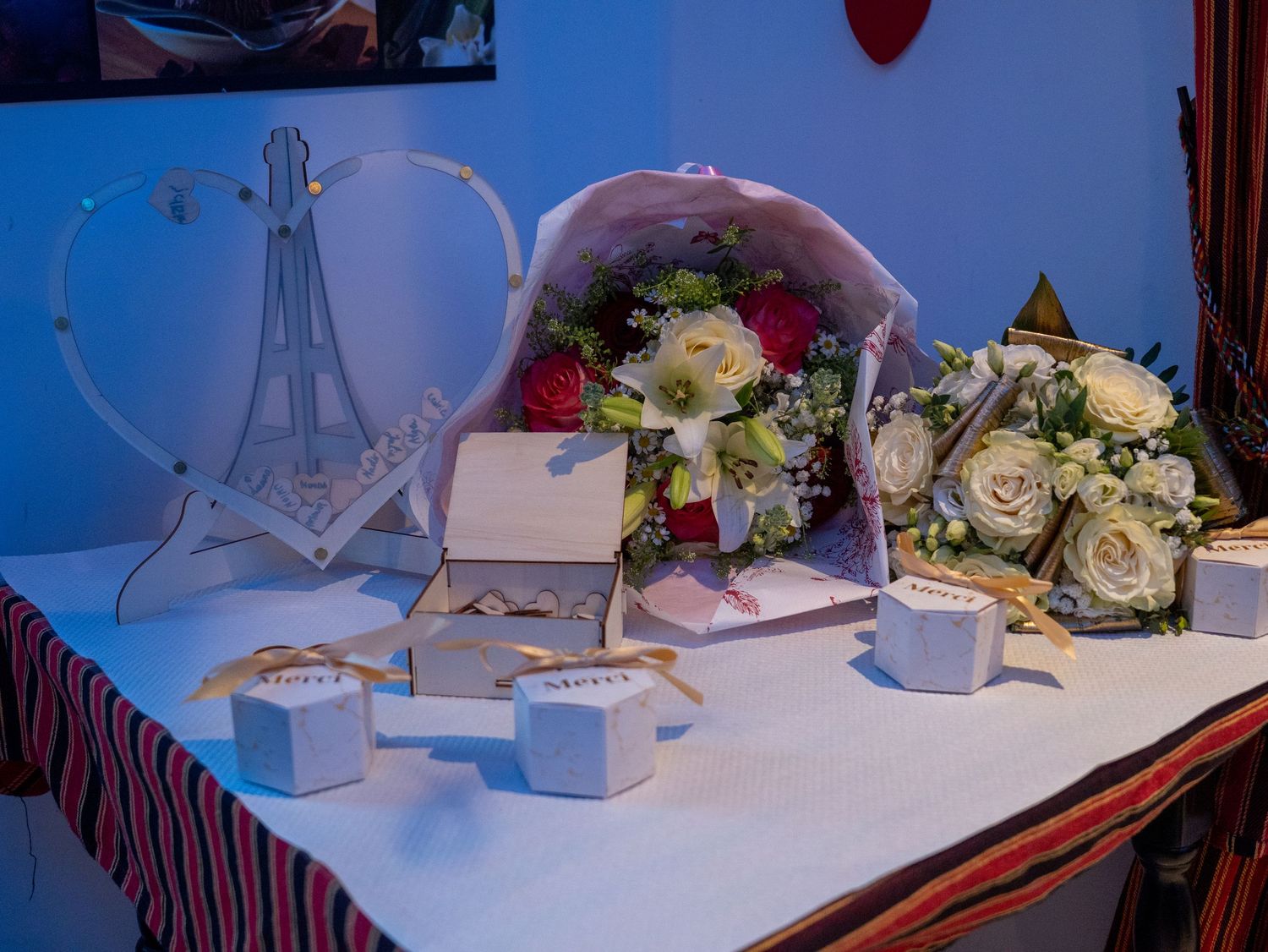 Romantic dinner table setting with Eiffel Tower decor, white roses, and soft lighting creates an intimate Parisian ambiance.