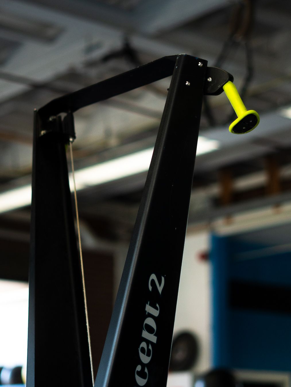 Close-up view of black bicycle frame tubes showing geometric angles and structural details in indoor lighting.