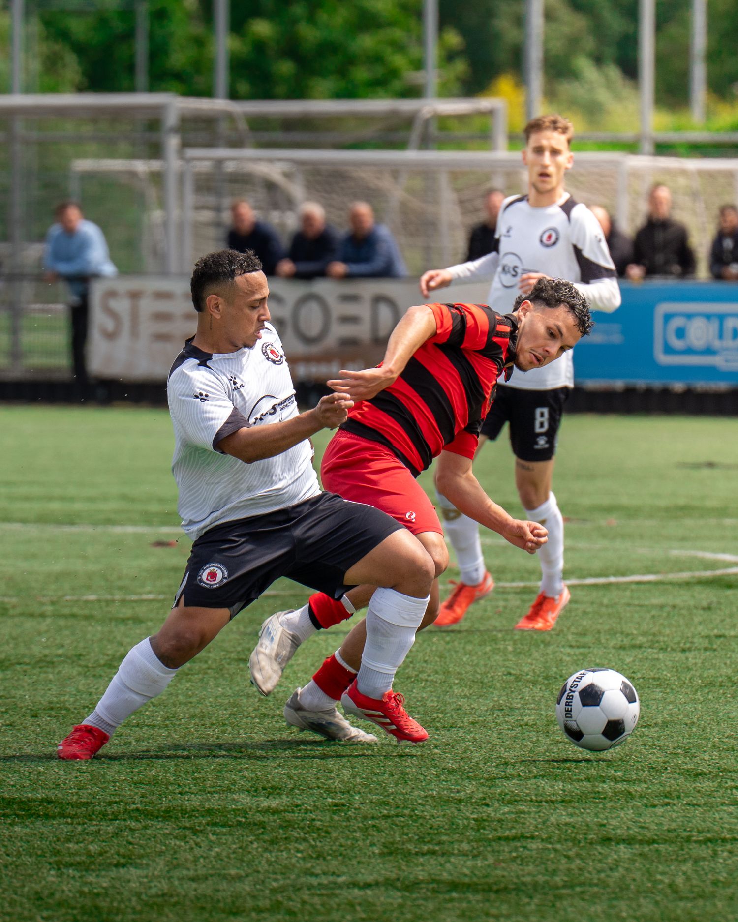 Soccer players compete for possession of the ball during an intense match on artificial turf.