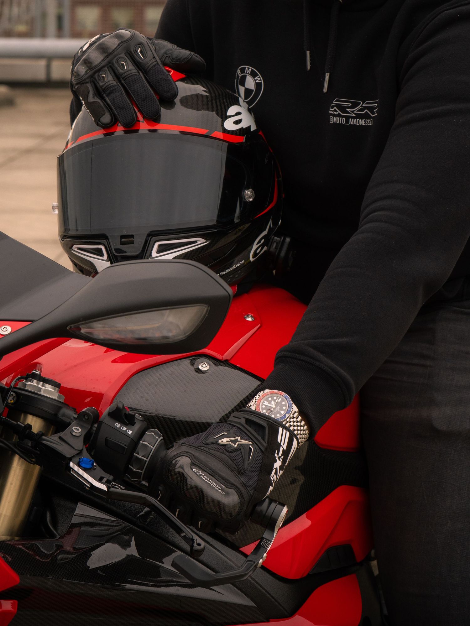 Close-up view of a red motorcycle with black helmet and protective gear mounted on the seat.