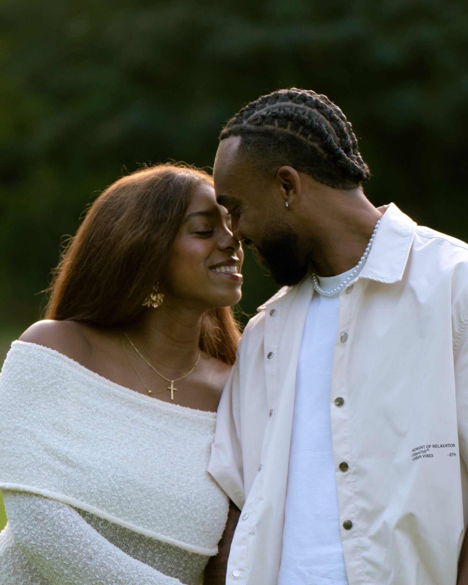 A couple in white outfits share intimate moments in a romantic outdoor photo series.