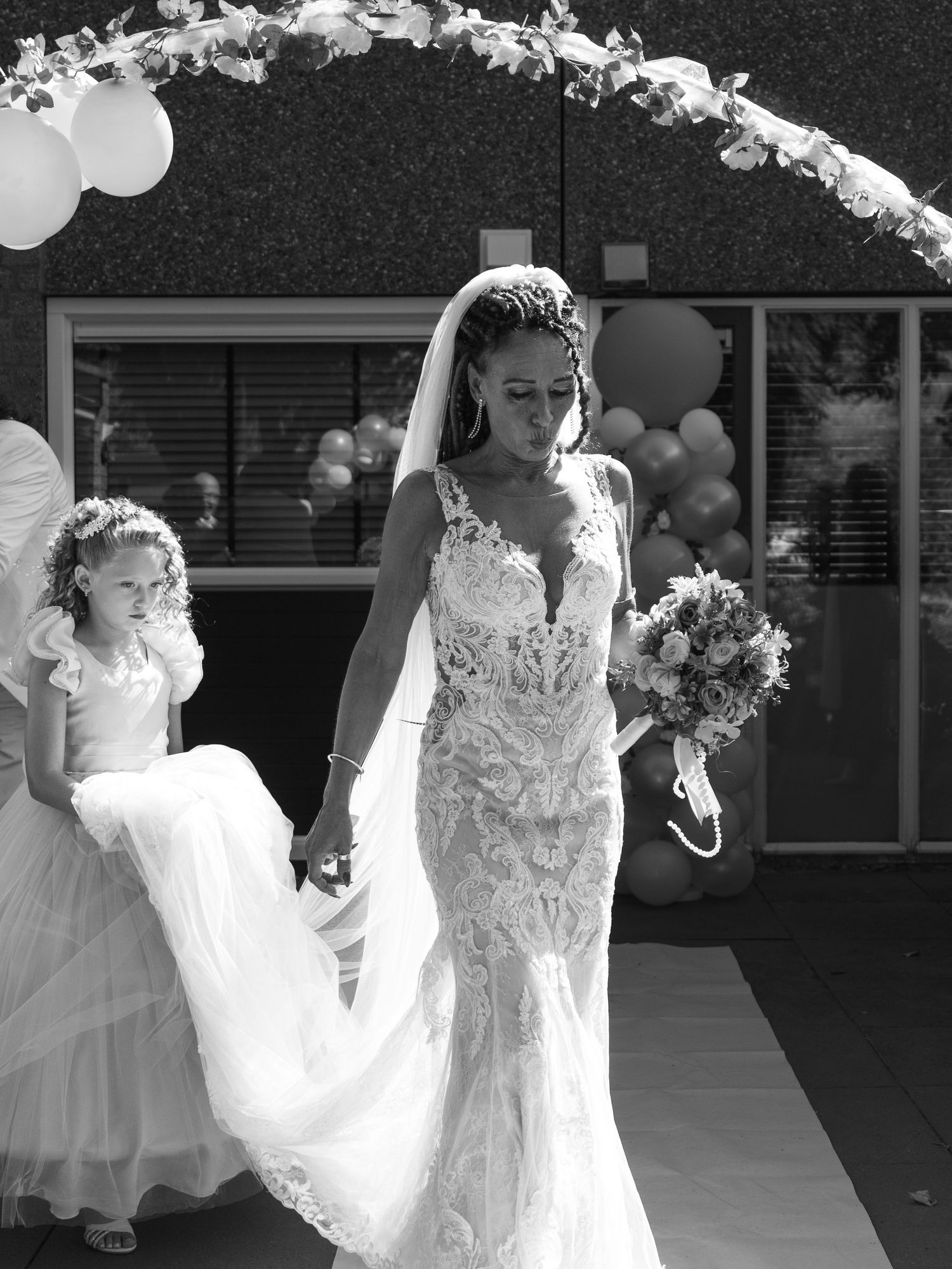 Black and white wedding photo collage showing bride and bridesmaid in elegant white dresses holding bouquets.