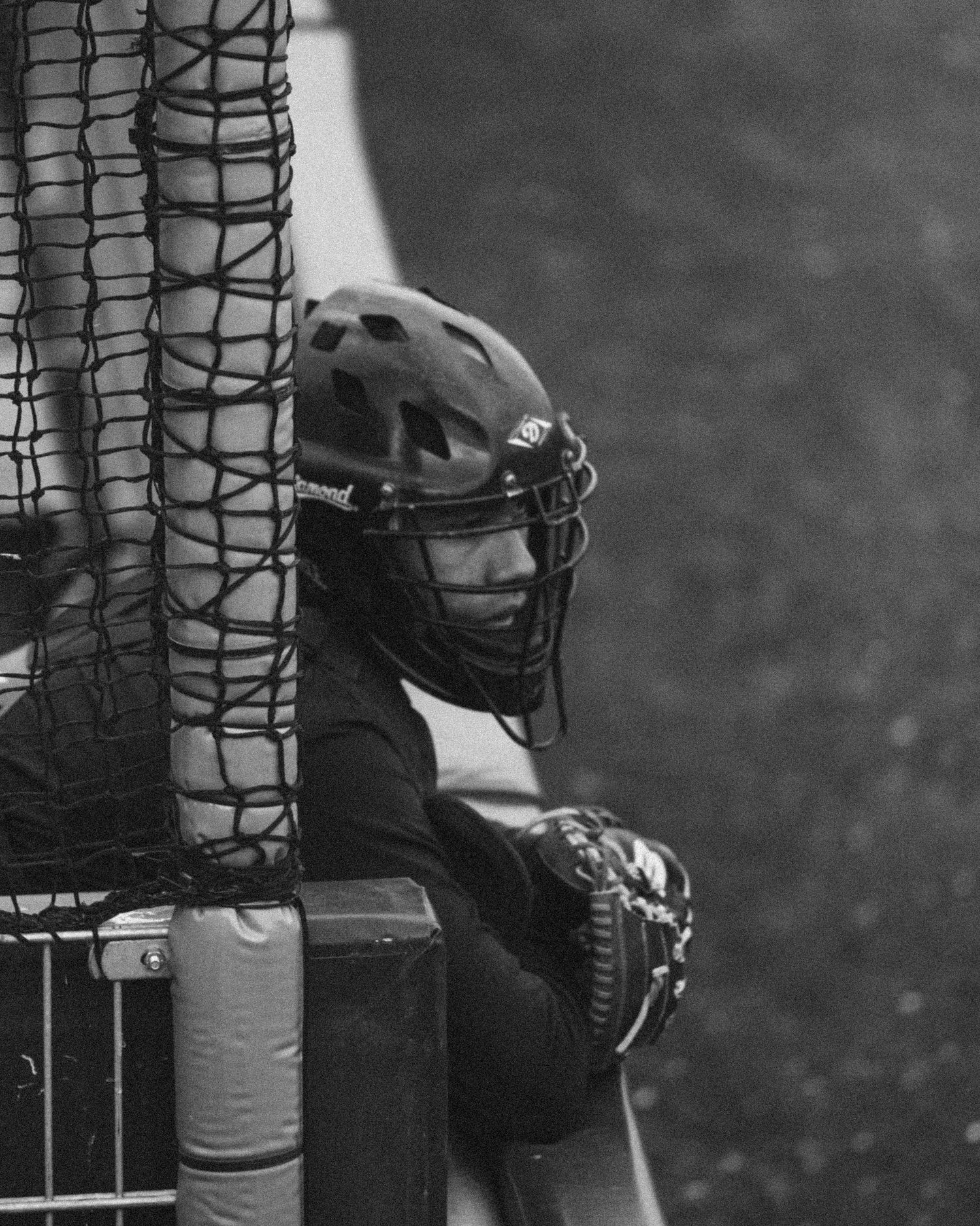 Black and white photograph showing a baseball player making contact with the ball during a game.