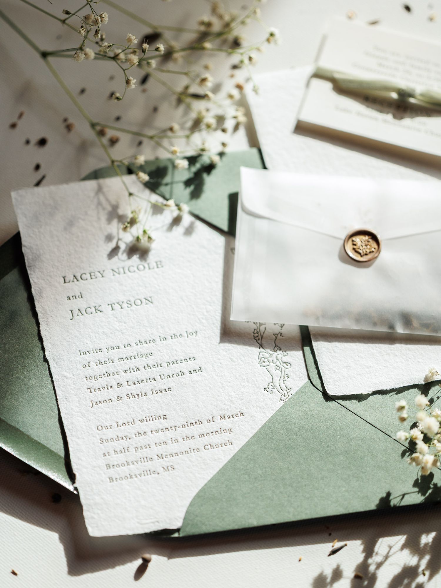 Elegant wedding invitation cards with handwritten calligraphy on textured paper with delicate floral details.
