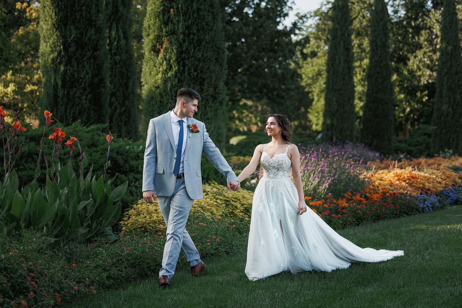 a bride and groom walking through a kansas garden on their wedding day