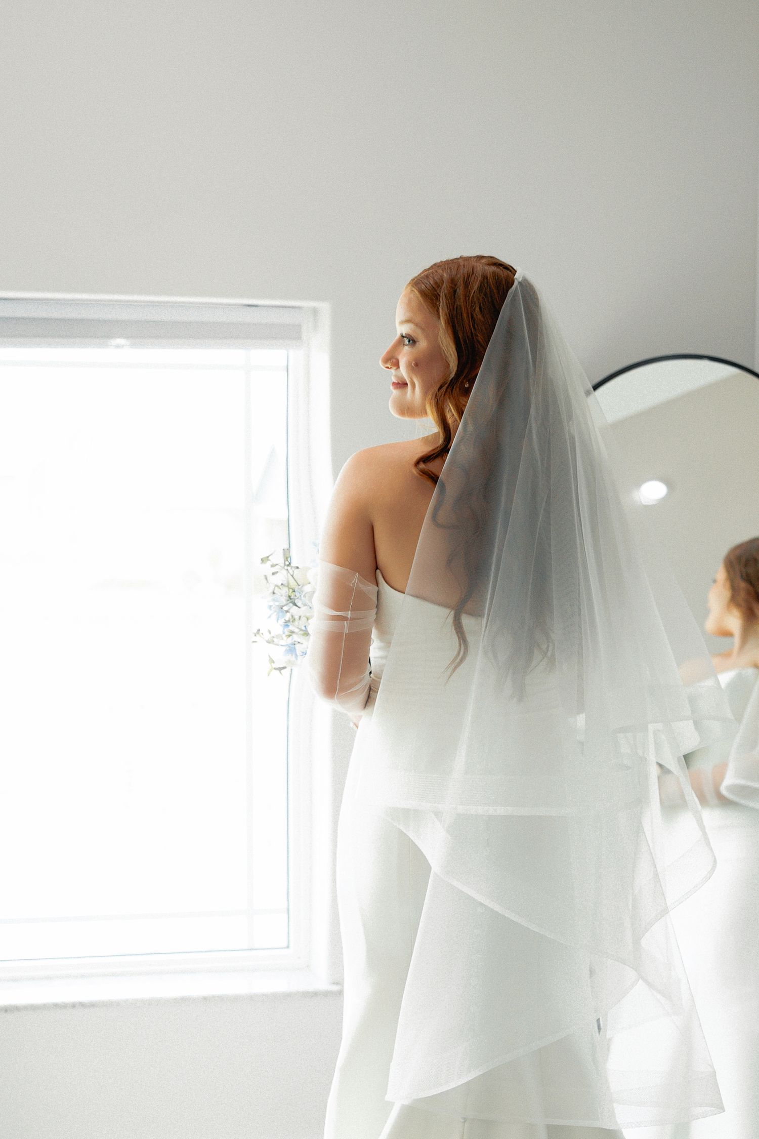 Ethereal Wichita Wedding bridal portrait with flowing white veil against bright window light.