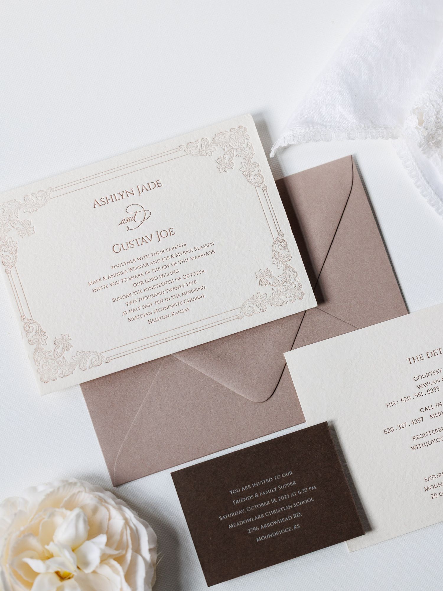 Elegant wedding invitation suite featuring beige and brown cards with delicate floral designs laid out on white surface.