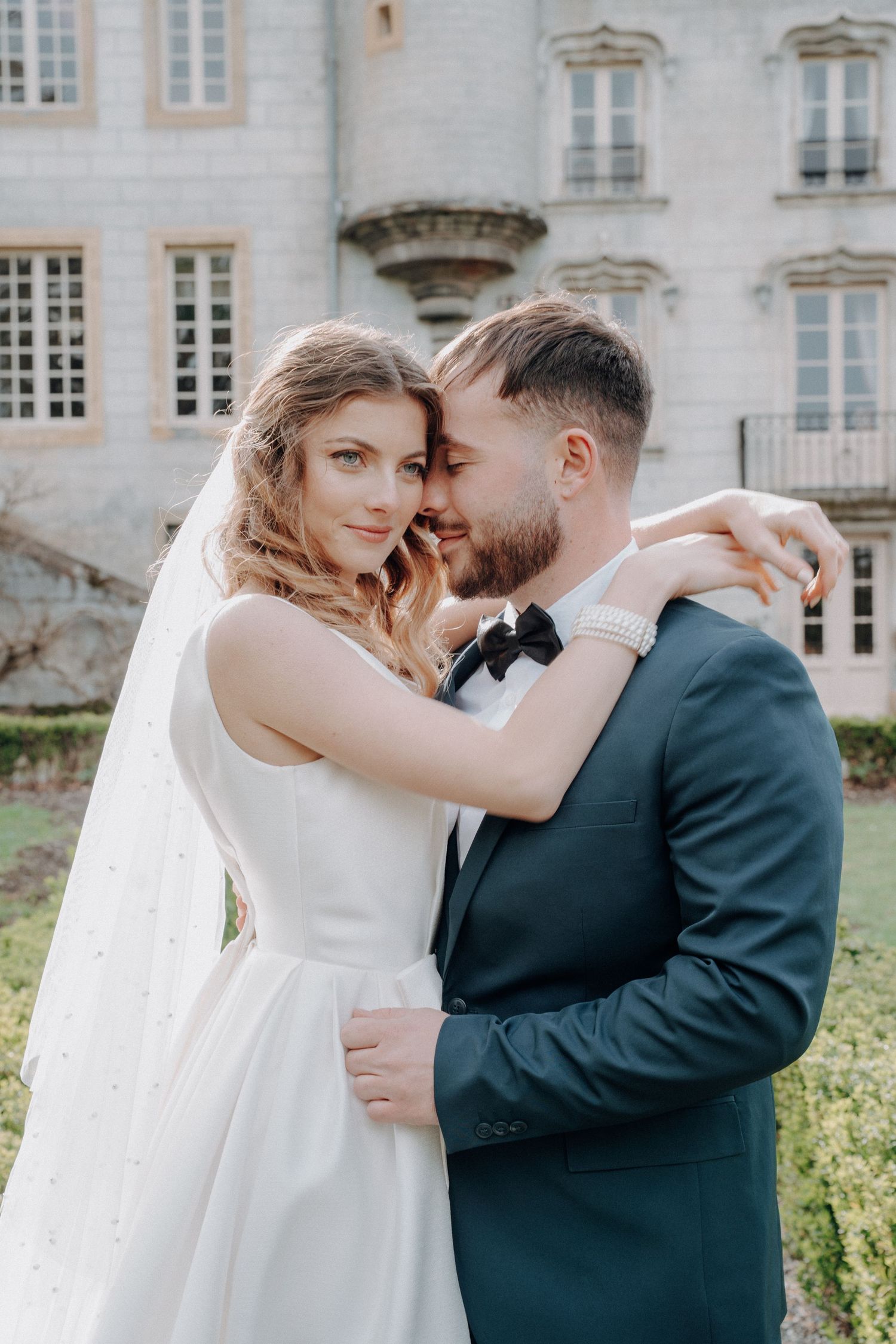 Intimate wedding portraits captured against a classic white mansion exterior.