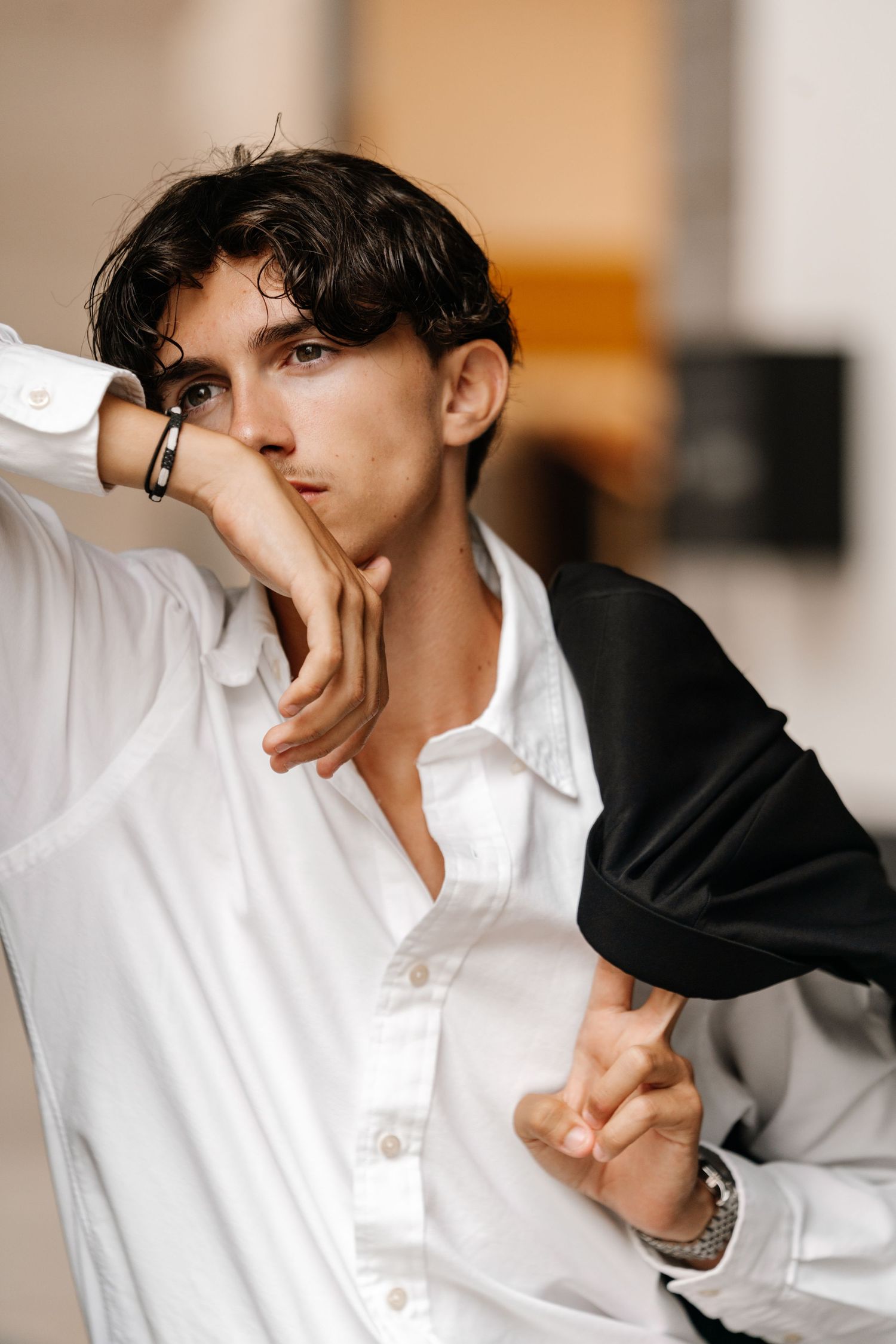 Artistic indoor photoshoot featuring crisp white shirt and dramatic poses.