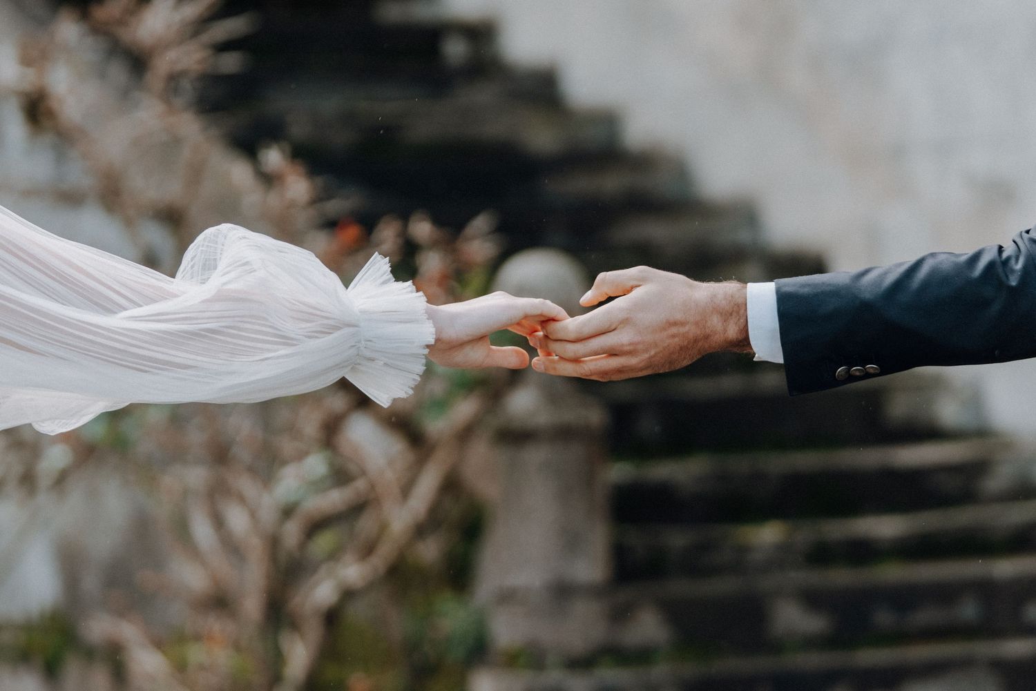 Close-up shot of hands exchanging wedding rings during ceremony.