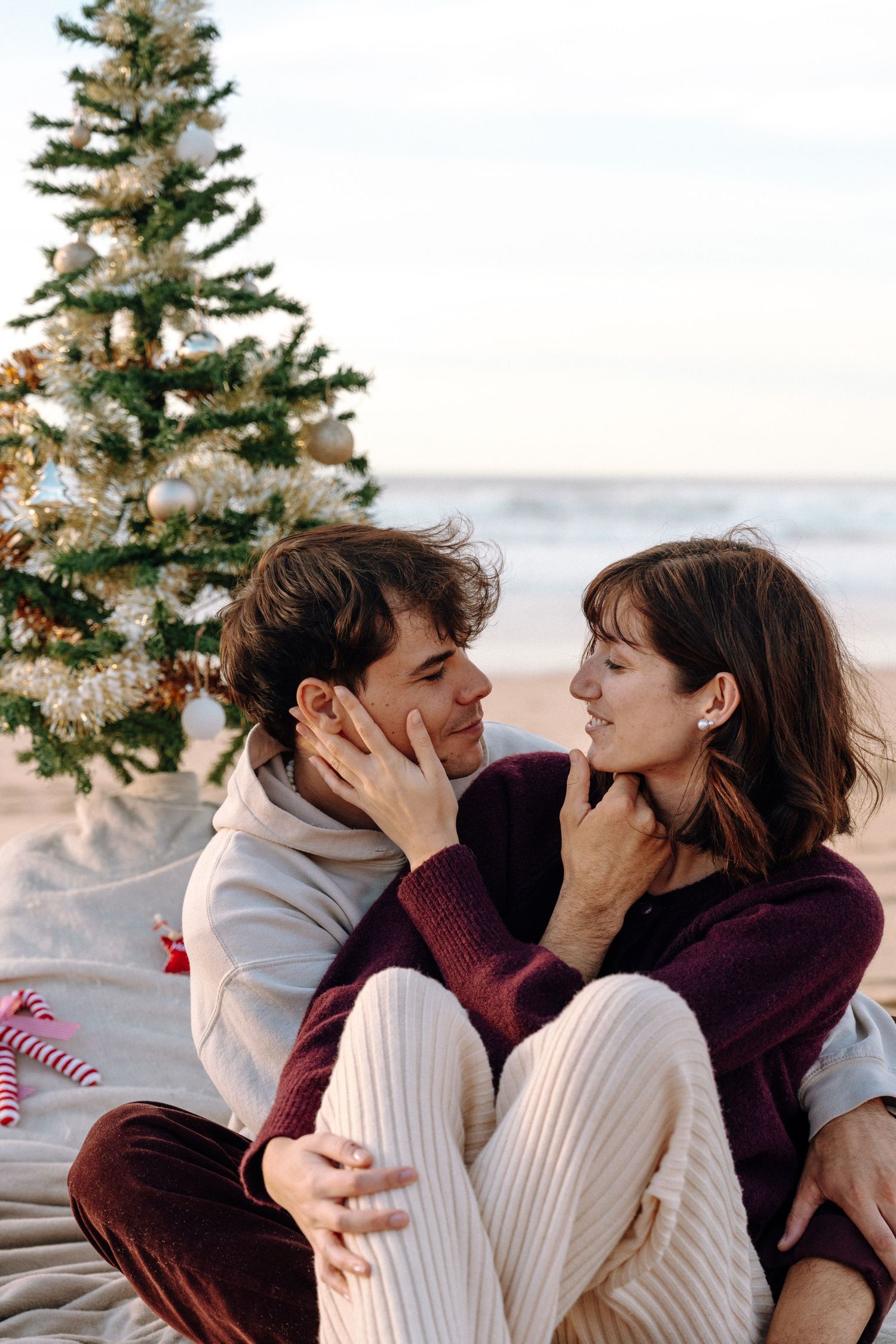 Cozy winter scene with decorated Christmas tree and intimate moments.