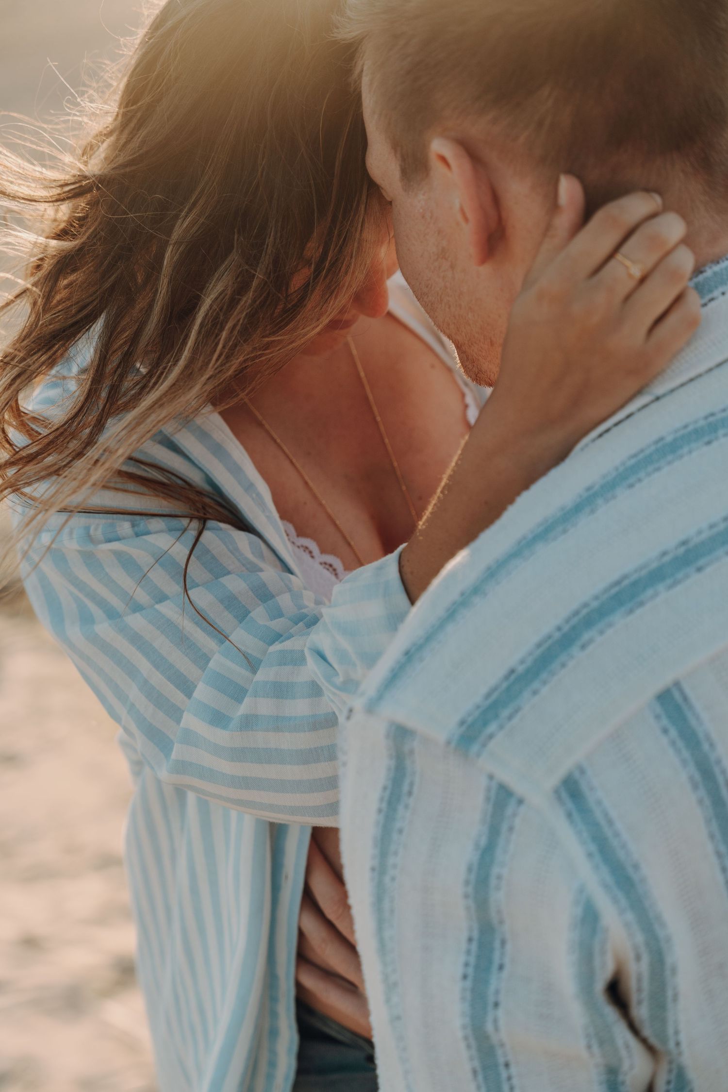 Close-up shots of couple sharing intimate moments during beachside maternity session.