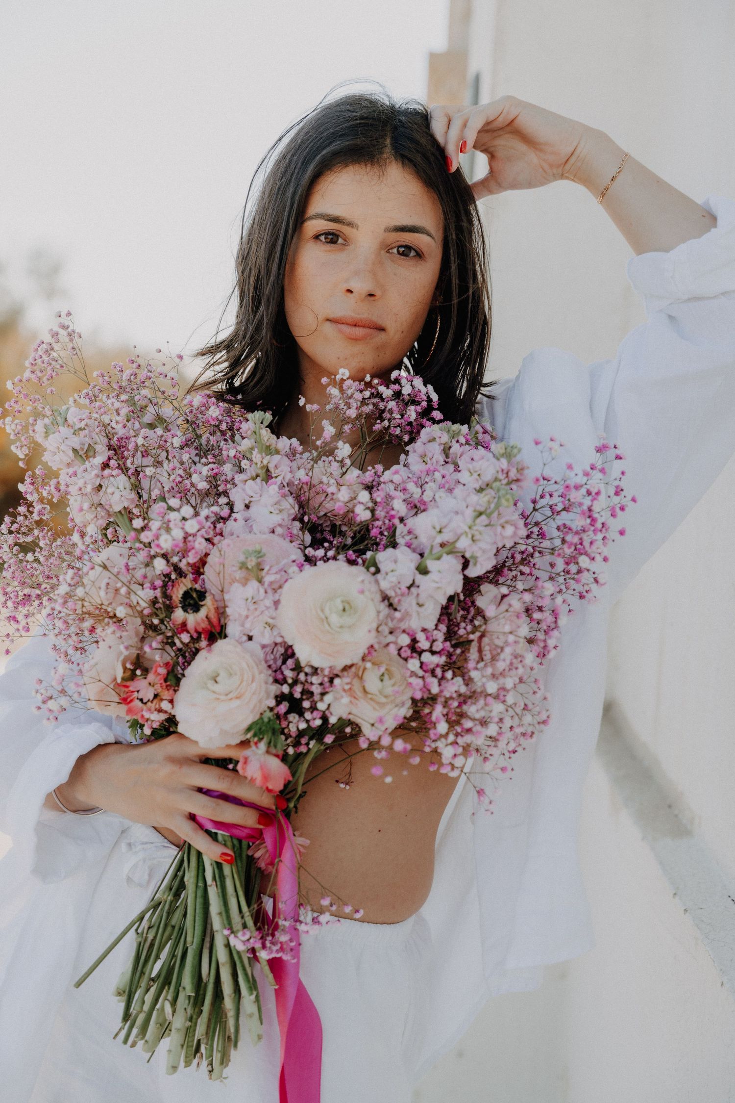 Dreamy collage of delicate pink baby's breath and white roses in a bridal bouquet against a light background.