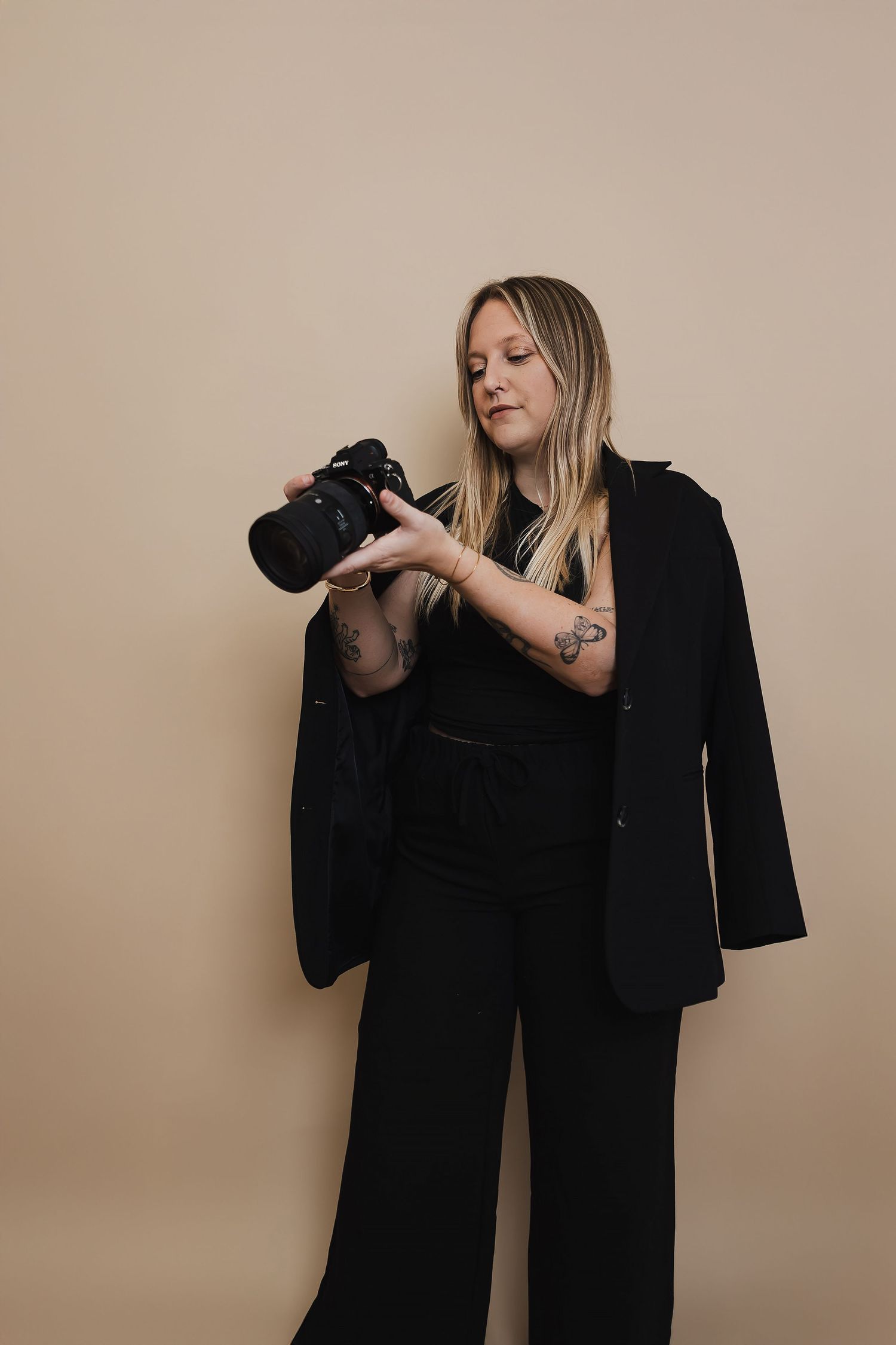 Professional photography session setup with camera equipment against beige background.