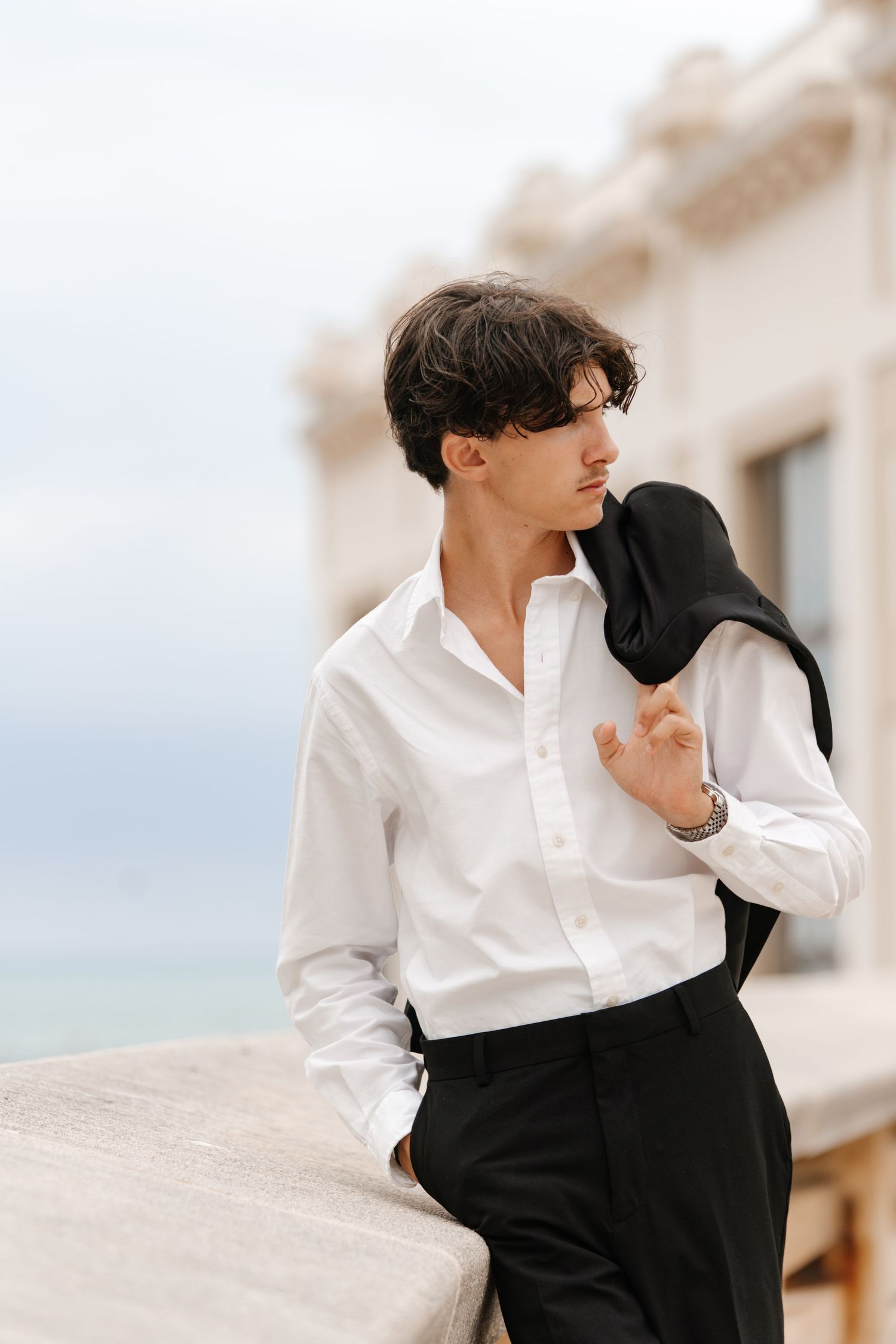 Fashion portrait series showing elegant black and white outfit styling against architectural backdrop.