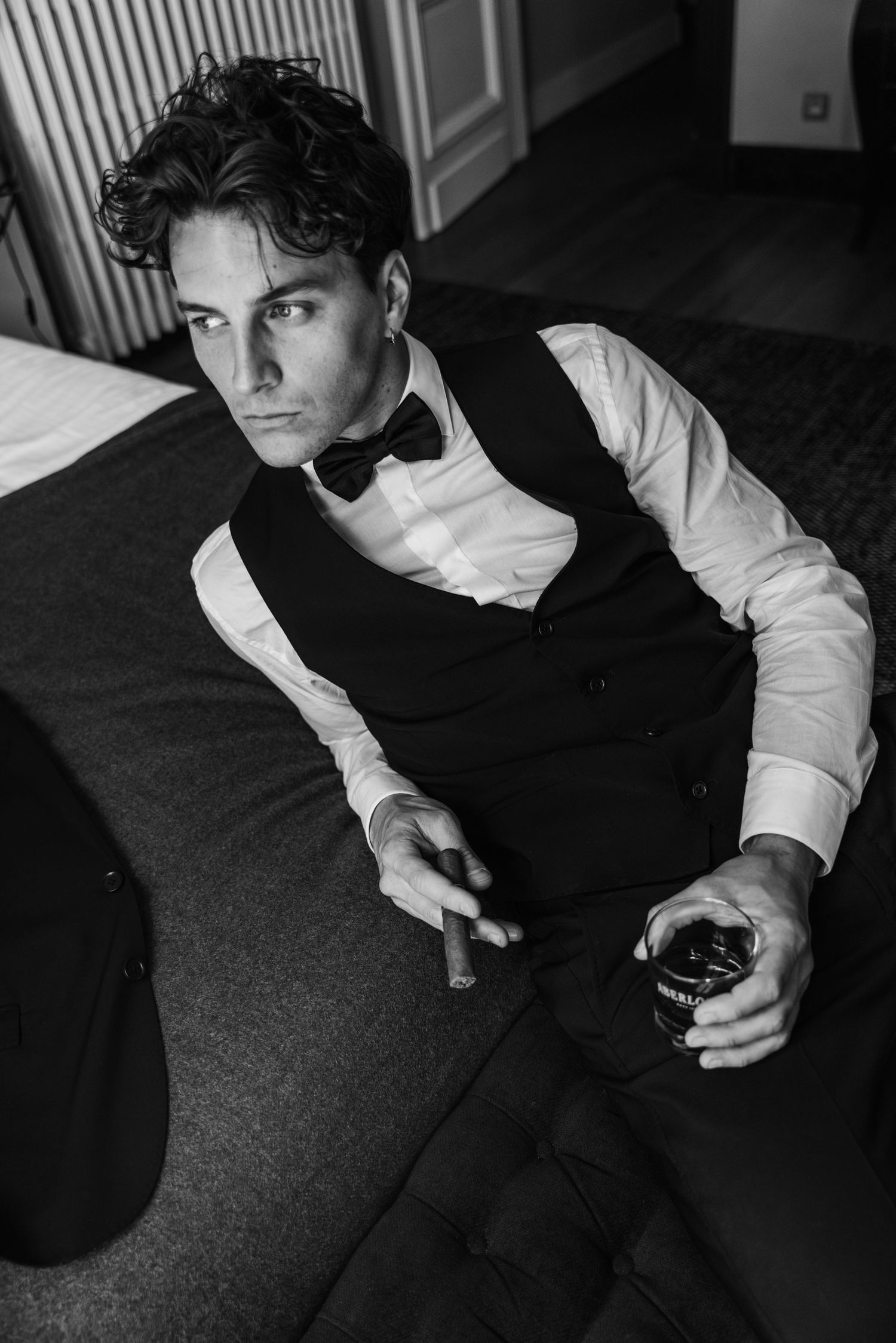 Dramatic black and white portrait of a formal evening attire with drink.