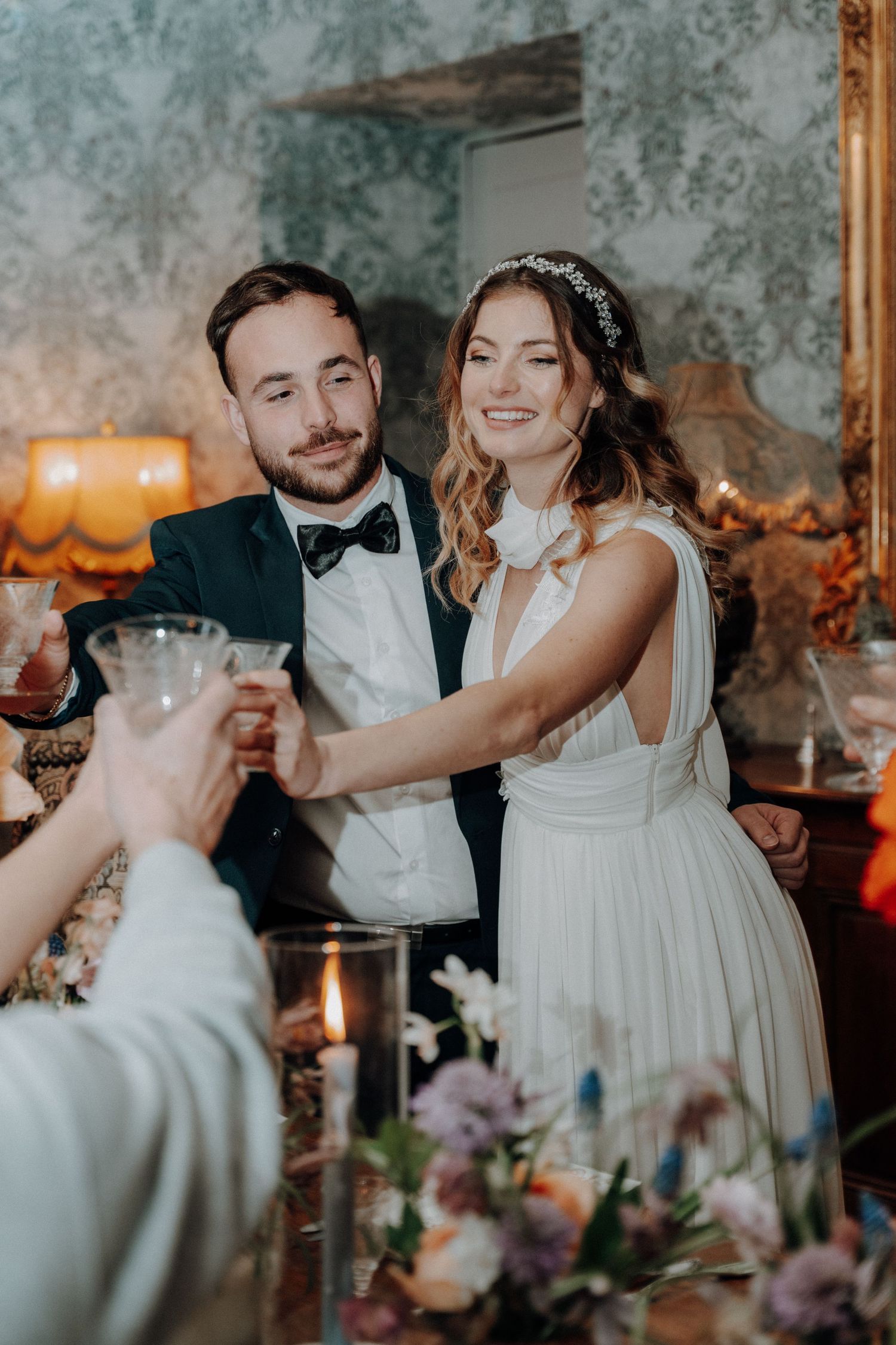 Candid wedding reception moments with champagne toasts in an elegant vintage setting.